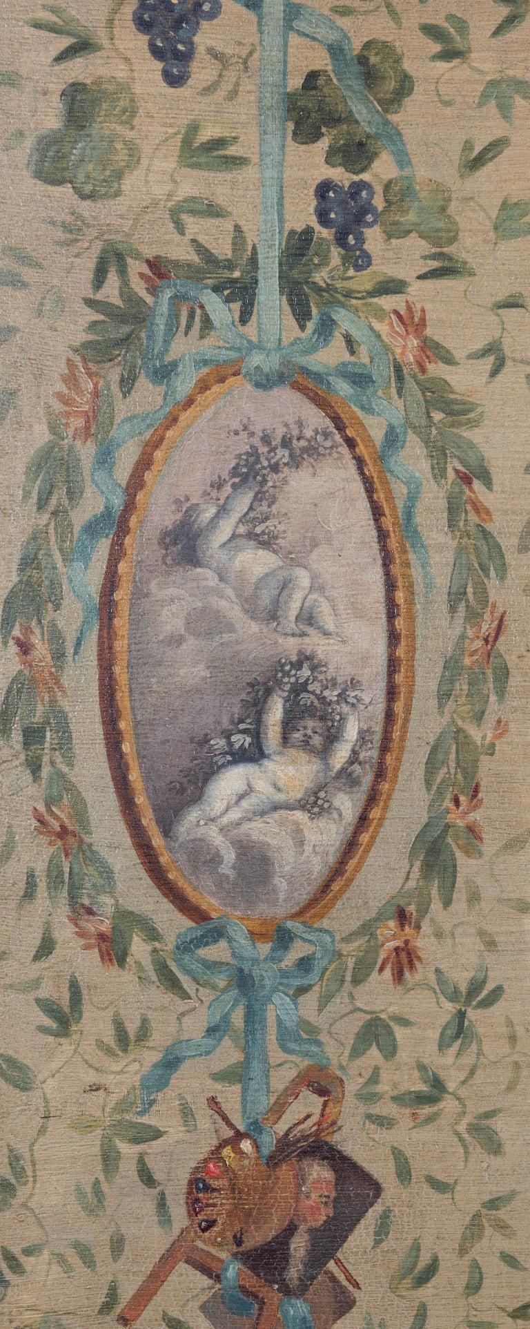 Each panel painted with classical oval shaped medallions depicting putti, surrounded by floral wreaths, musical trophies, foliage and ribbons on a pale olive green ground.