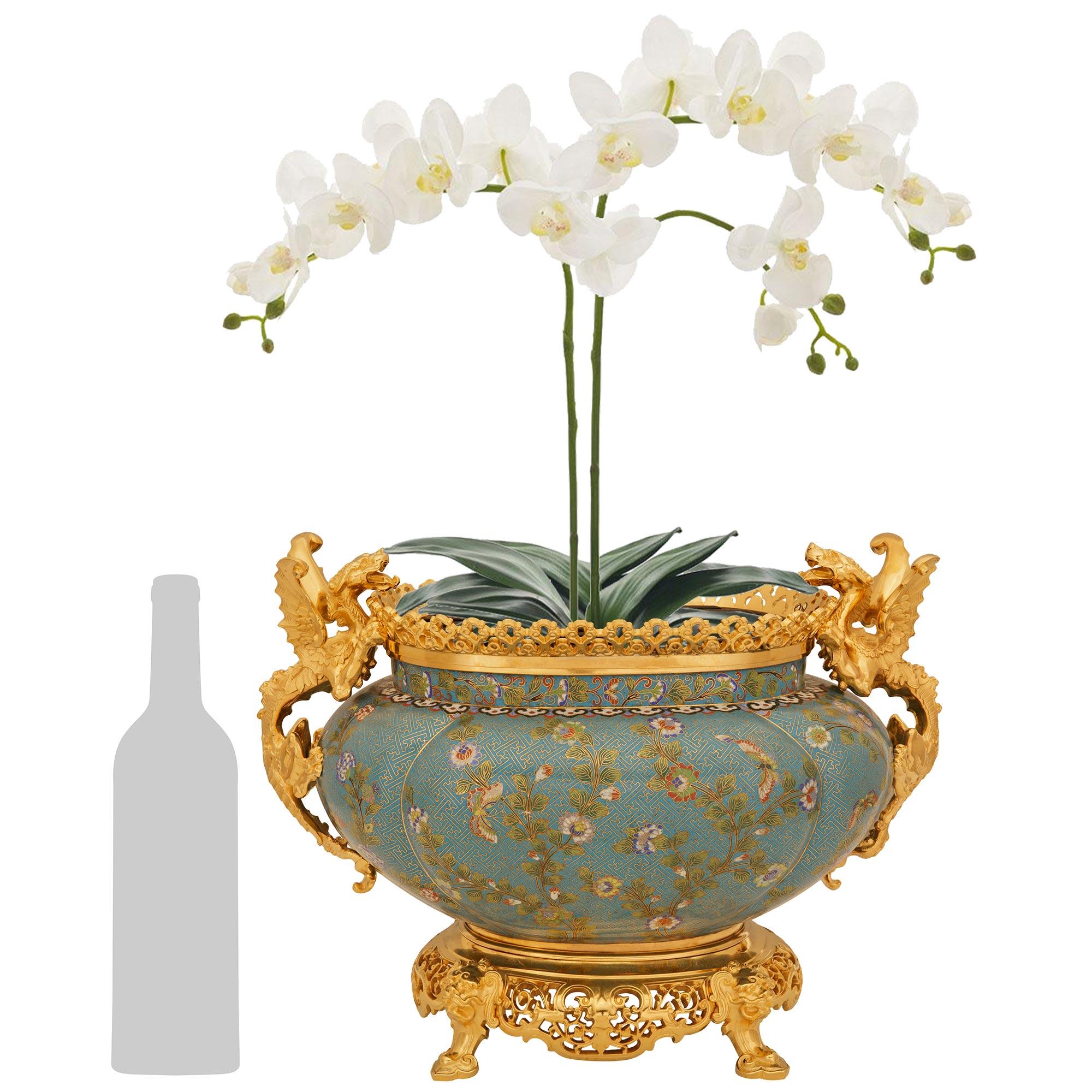 Un superbe et très élégant vase/vase en cloisonné et bronze doré de la période japonaise de la Belle Epoque du 19e siècle. Cette magnifique Jardinière repose sur quatre pieds à volutes qui soutiennent une base en bronze doré finement ciselé et