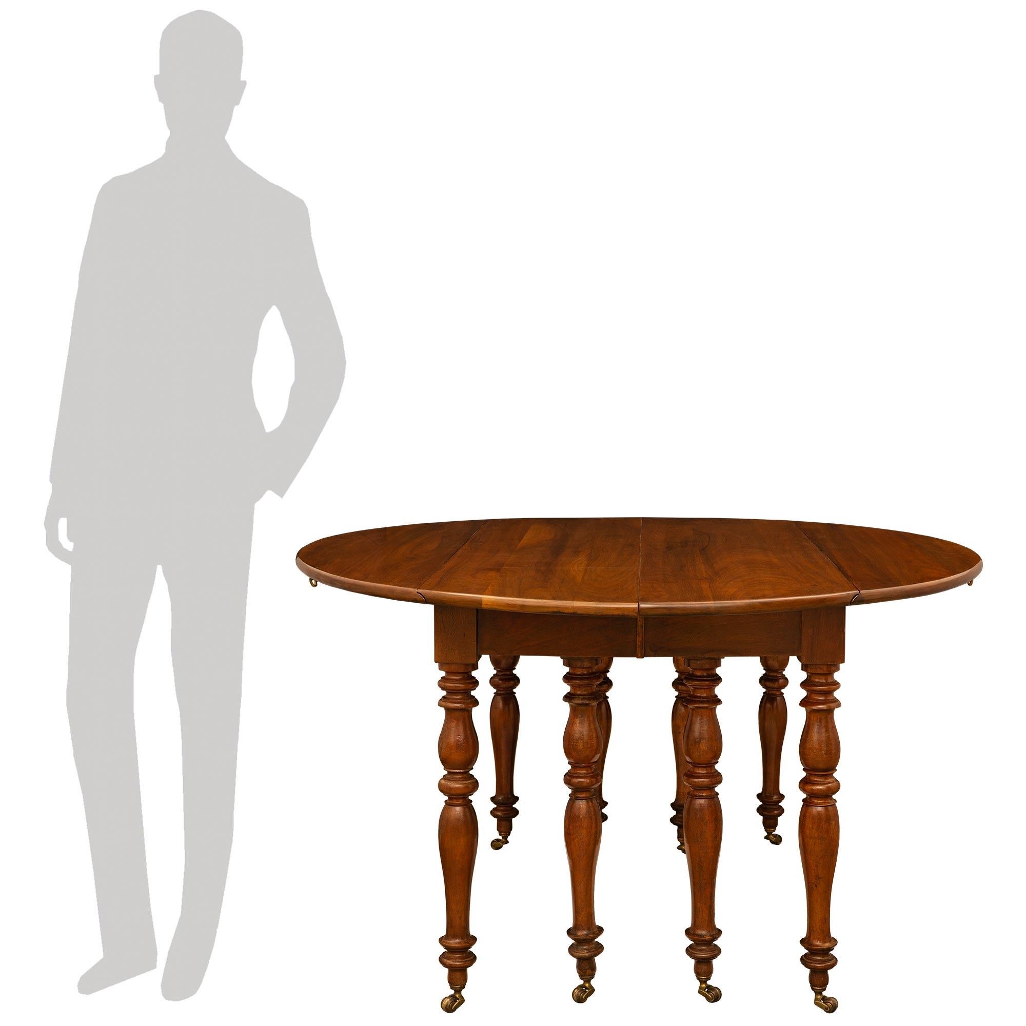 Très belle table de salle à manger en noyer de style Louis Philippe du XIXe siècle. Cette magnifique table de salle à manger repose sur huit pieds droits à bords marbrés, supportés par leurs roulettes d'origine. Cette table palatiale peut avoir les