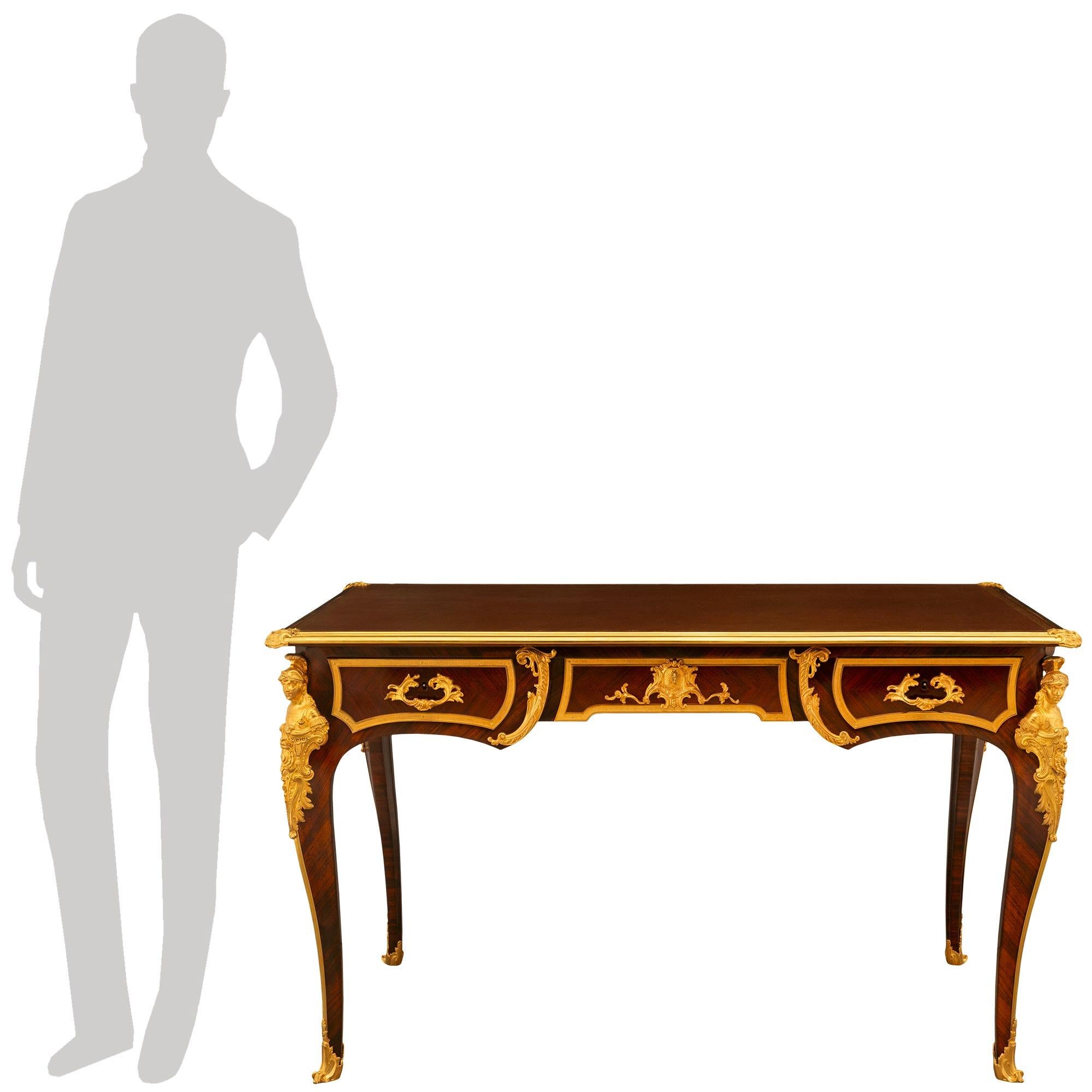 A stunning and high quality French 19th century Louis XV st. Kingwood and Ormolu Bureau Plat. The desk is raised by elegant cabriole legs with rich wrap around ormolu sabots. Ormolu chutes connect the richly chased corner ormolu mounts of soldiers