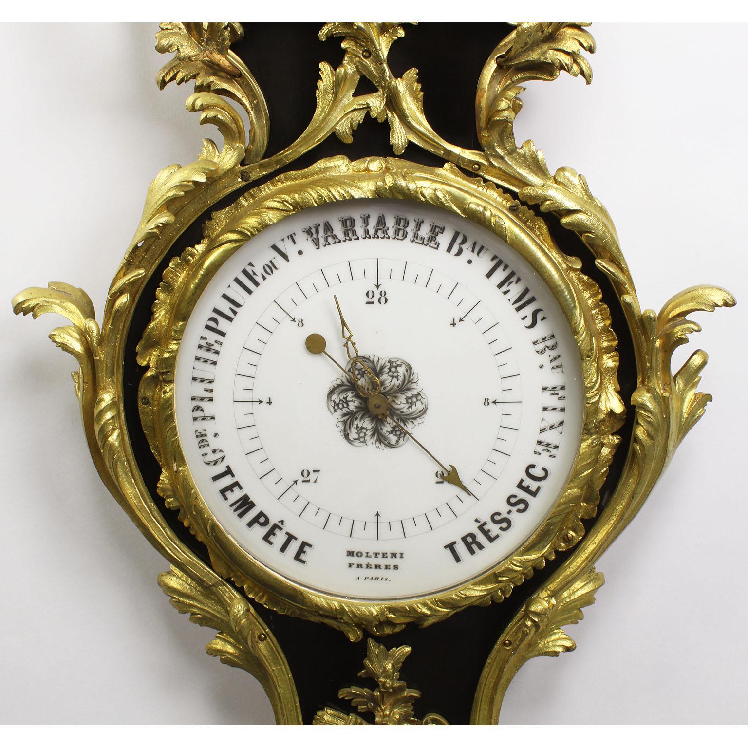 A fine French 19th century Louis XV style gilt-bronze and ebonized wood wall-mounting barometer - thermometer by Molteni Frères. The elongated ebonized body surmounted with gilt-bronze ornaments depicting scrolls, acanthus and floral bouquets with
