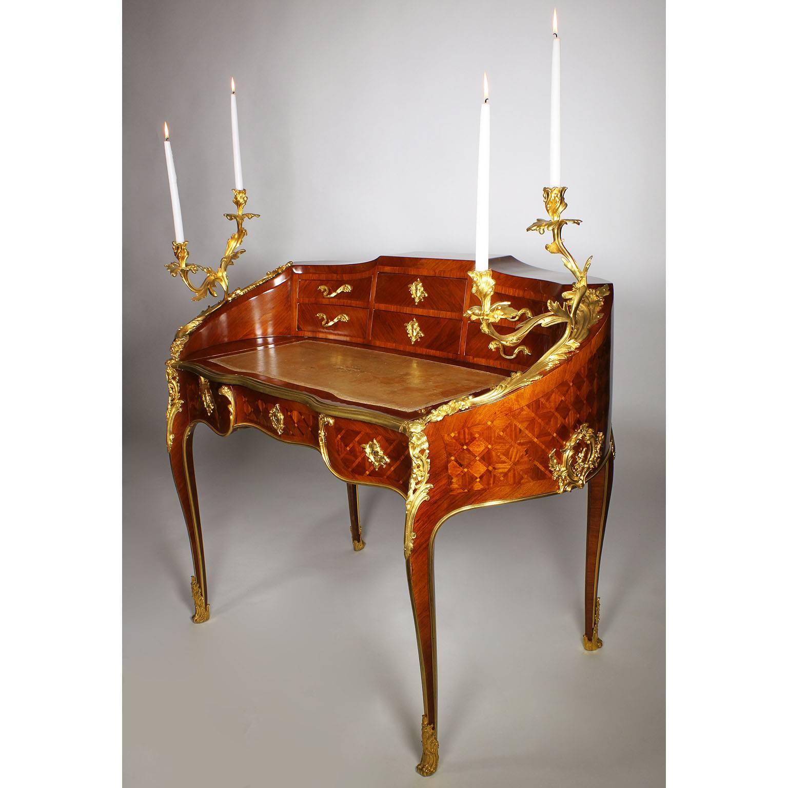 A very fine French 19th century Louis XV style gilt bronze-mounted kingwood and tulipwood parquetry decorated bombé secretary bureau-plat, attributed to Maison Millet. The kidney shaped body surmounted with a pair of two-light gilt bronze scrolled
