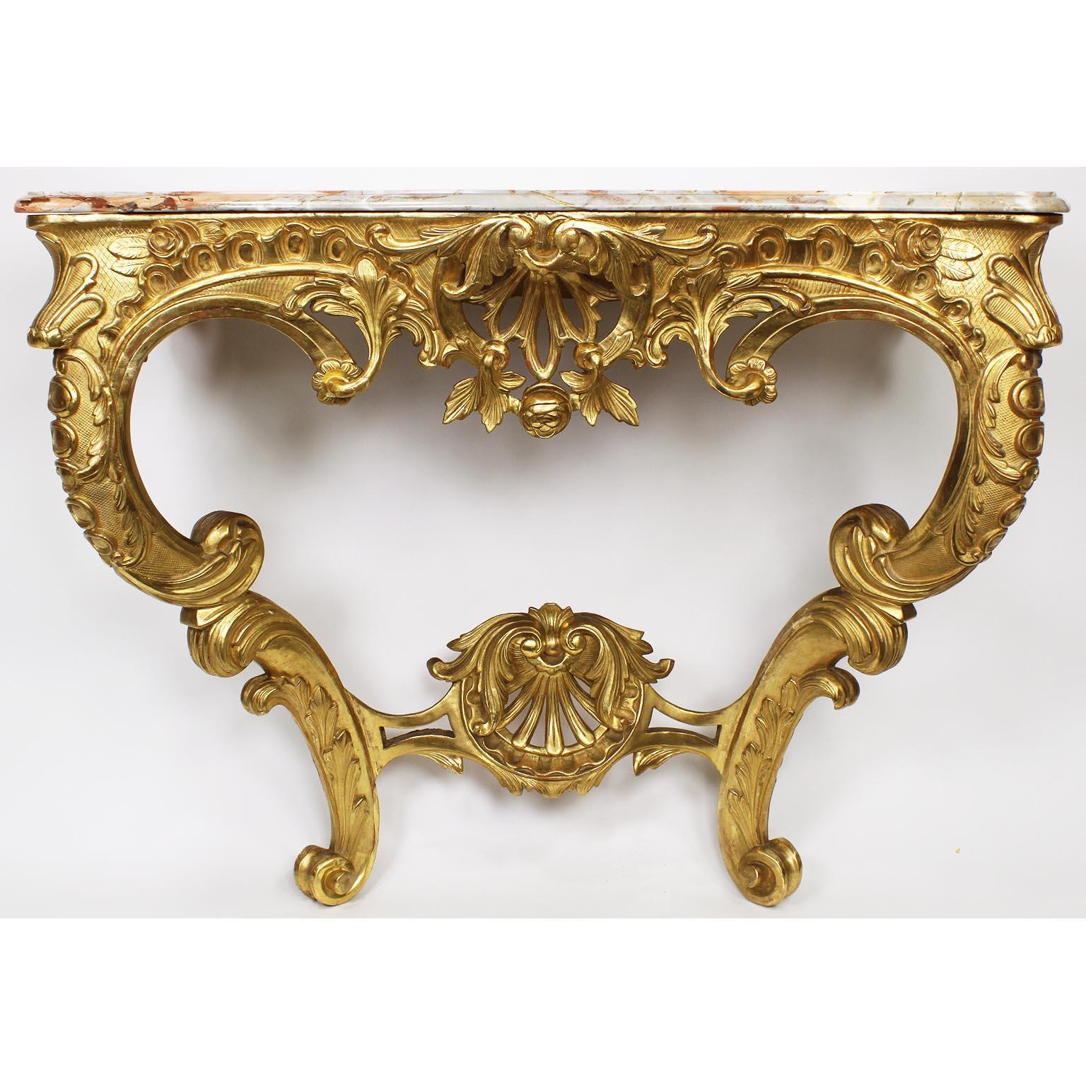 A fine French 19th century Louis XV style giltwood and Gesso carved wall-mounting console table with marble top. The ornately carved apron with scrolls, acanthus, shells and floral designs, raised on twin cabriolet legs conjoined with a carved shell