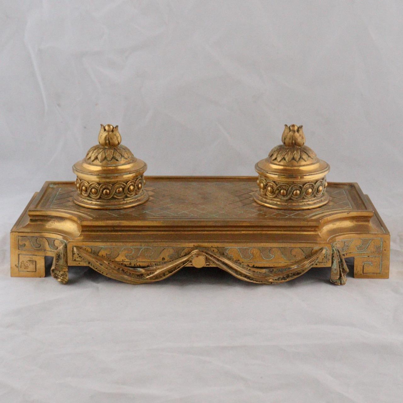 A French 19th century Louis XVI style Ormolu inkwell 
An Ormolu Double inkwell decorated with Greek-style latticework, rosettes and friezes, highlighted with drapery. The dildos decorated with piastre friezes, shaped like floral buttons and