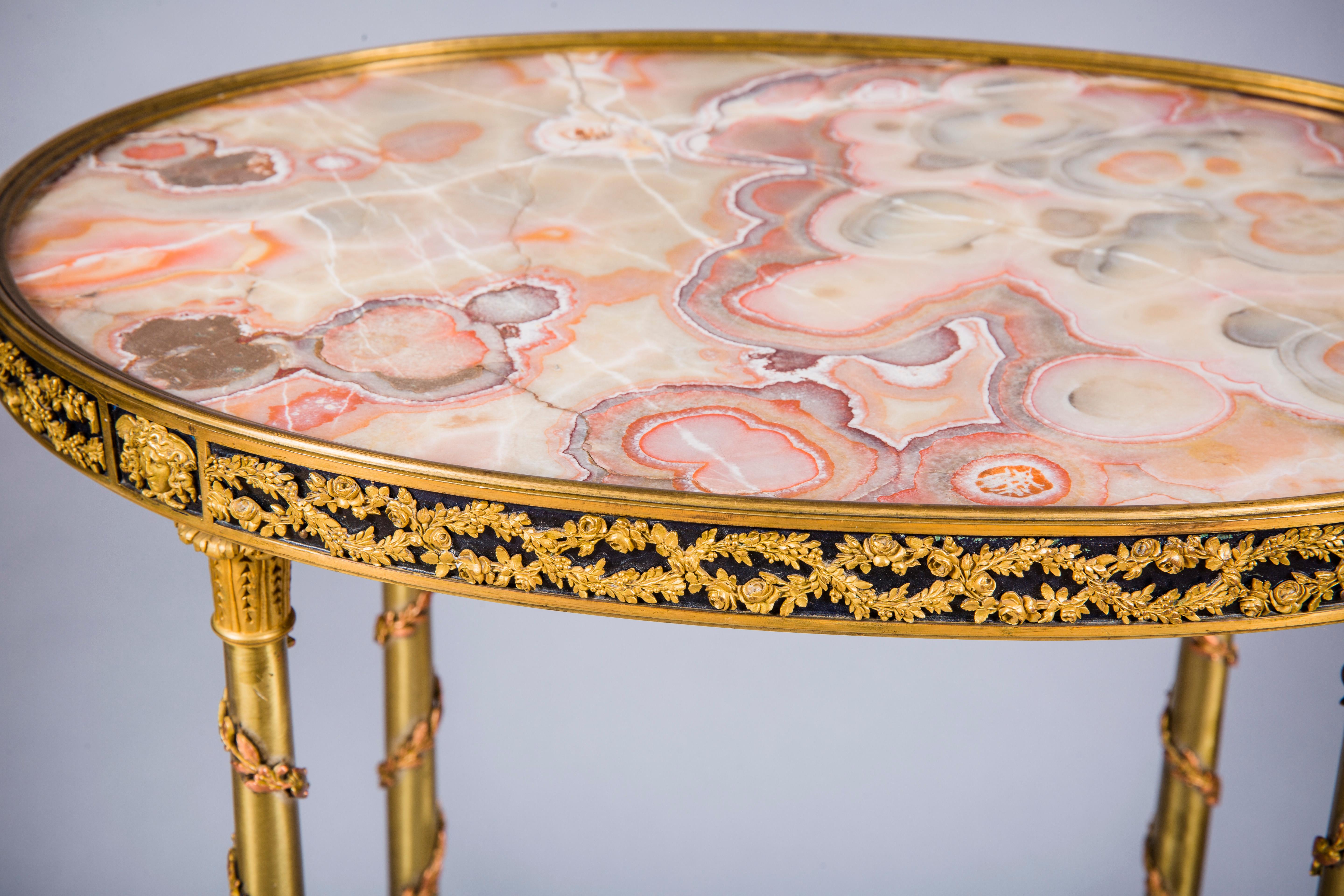 A French gilt bronze guéridon side table
Applied ormolu bronze wreath with medusa bordering along the oval-shaped frame with inset hardstone top above a set of four intricately chiseled gilt ormolu legs decorated by foliate ormolu spirals joined by