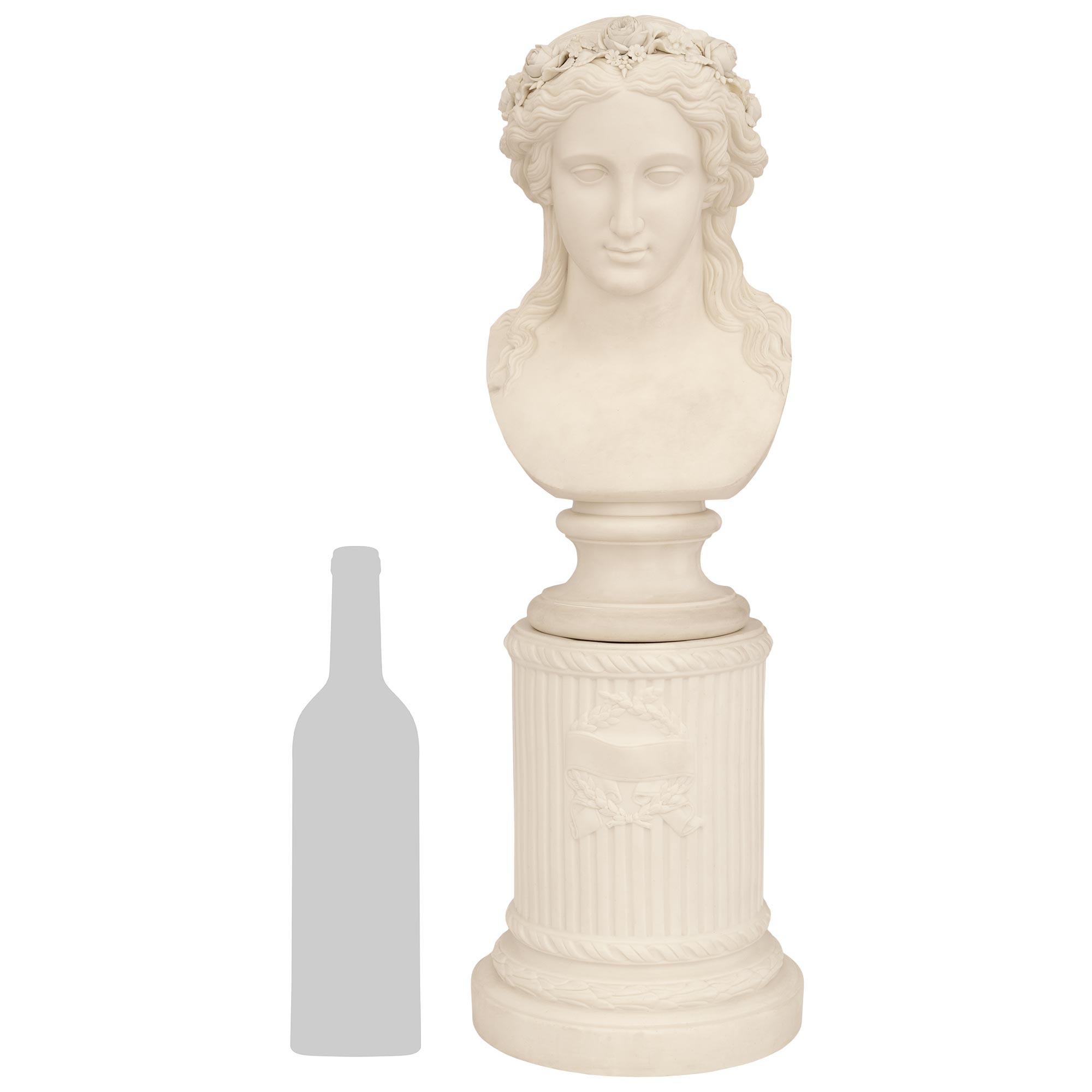 Un buste élégant et de grande qualité en porcelaine biscuitée de style Louis XVI du XIXe siècle. Ce charmant buste en porcelaine, composé de deux pièces, est surmonté d'une colonne circulaire cannelée, ornée de lauriers et de bandes inférieures et