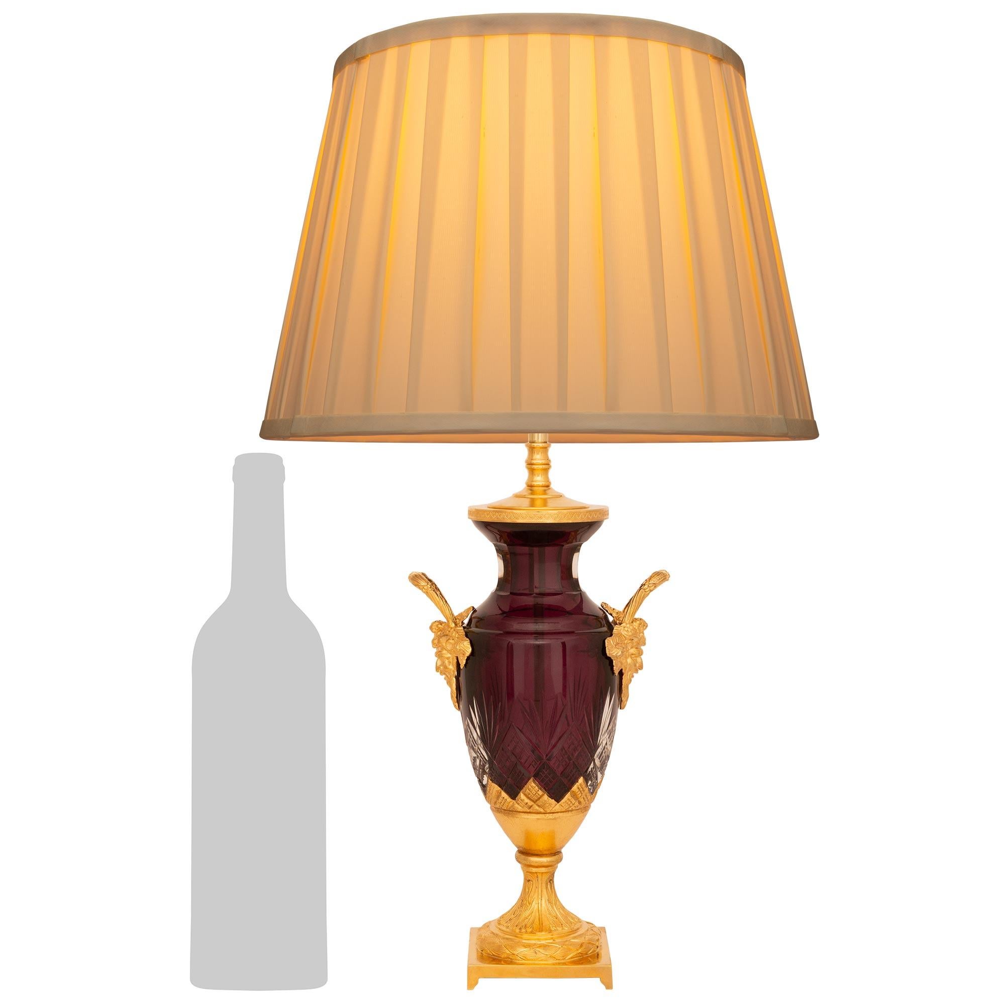 Atractiva lámpara francesa del siglo XIX de cristal y ormolu de estilo Luis XVI. Esta exquisita urna montada en una lámpara se eleva sobre una base cuadrada con un pedestal en forma de zócalo decorado con follaje. El zócalo sostiene la urna en forma