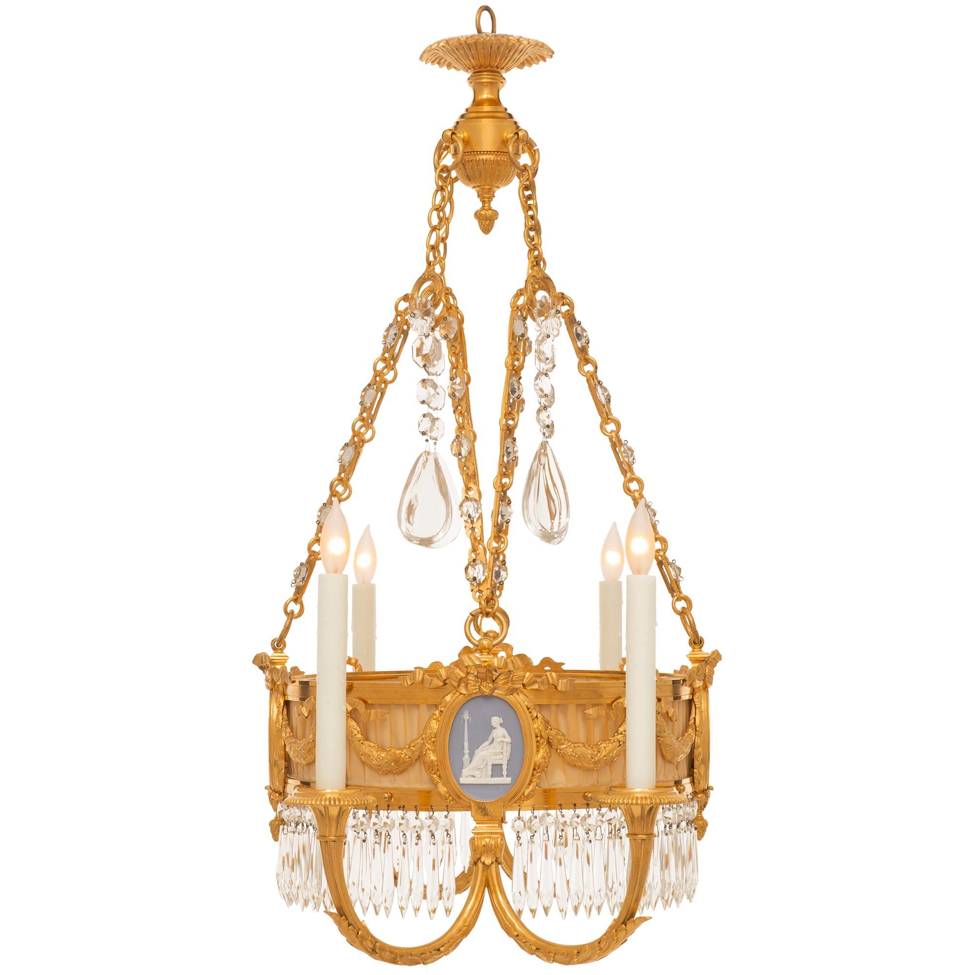 


A most elegant French 19th century Louis XVI st. ormolu, Wedgwood porcelain and crystal chandelier. The six light chandelier has a central circular ormolu frame decorated by swaging berried laurel garlands which are held up by large bows. The