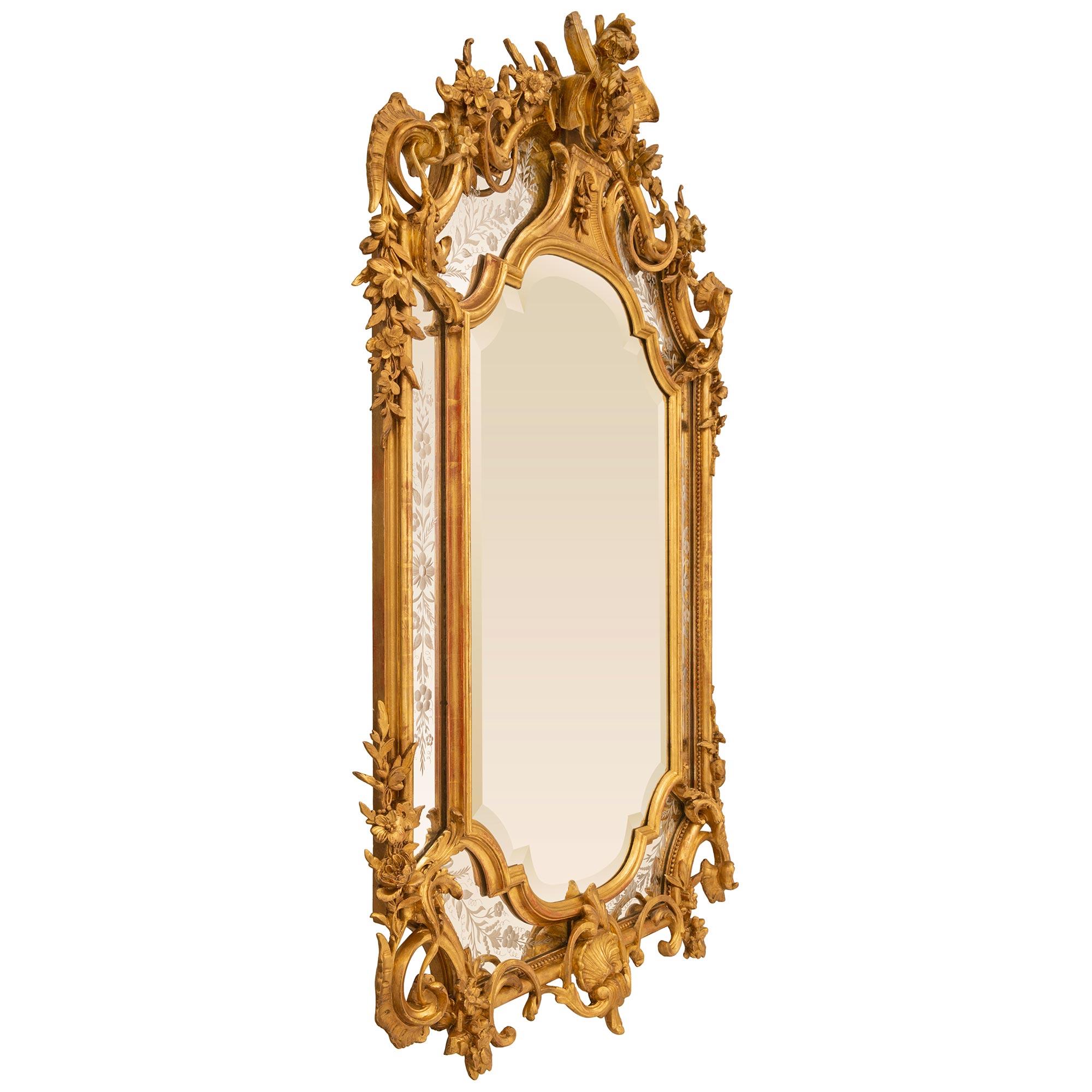 A most impressive and extremely elegant French 19th century Louis XVI st. Giltwood double frame mirror. The central mirror plate is surrounded by a mottled border while the outer mirror plates are richly decorated by etched designs of foliate and