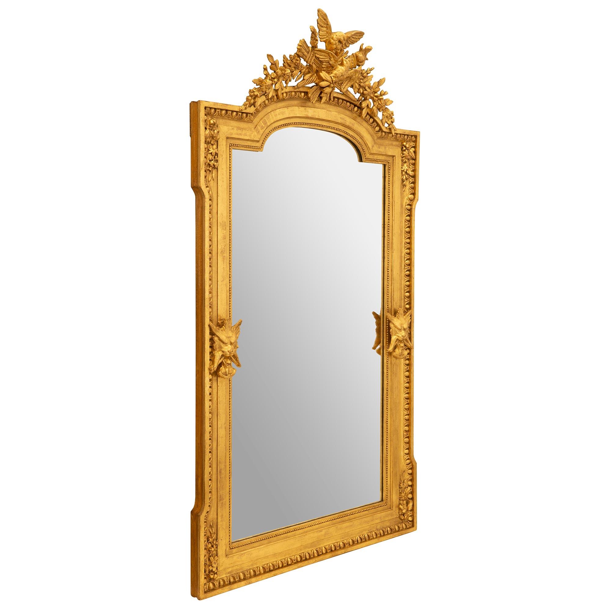 Ein auffälliger französischer Spiegel aus vergoldetem Louis XVI des 19. Der Spiegel behält seine ursprüngliche Spiegelplatte, die von einer feinen gesprenkelten Perlenbordüre umrahmt ist. Ein wunderschönes Les Oves Design erstreckt sich über den