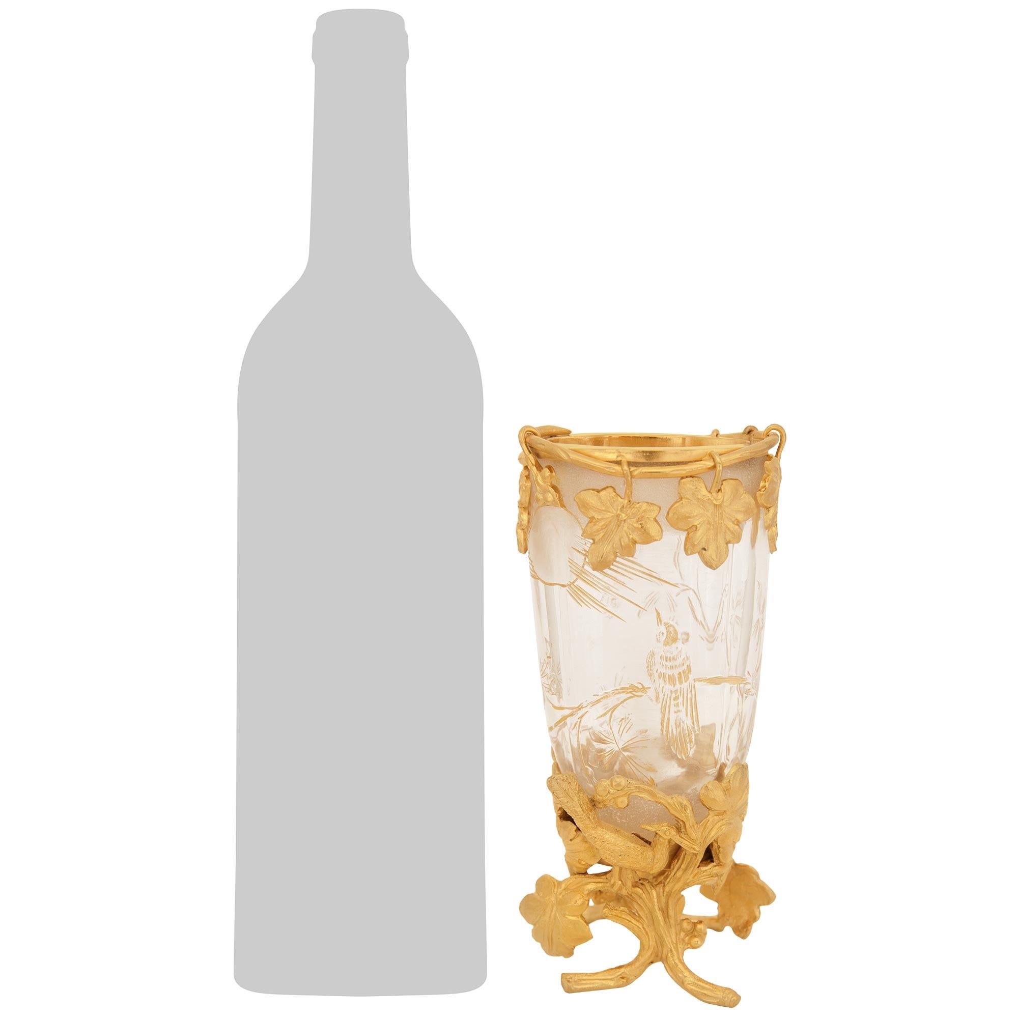 Un vaso di alta qualità e unico nel suo genere, in ormolu e cristallo di Baccarat, risalente al XIX secolo. Questo elegante vaso di cristallo Baccarat inciso è sollevato su una base di Ormolu traforata a forma di rami tra bacche e uccelli. Il vaso