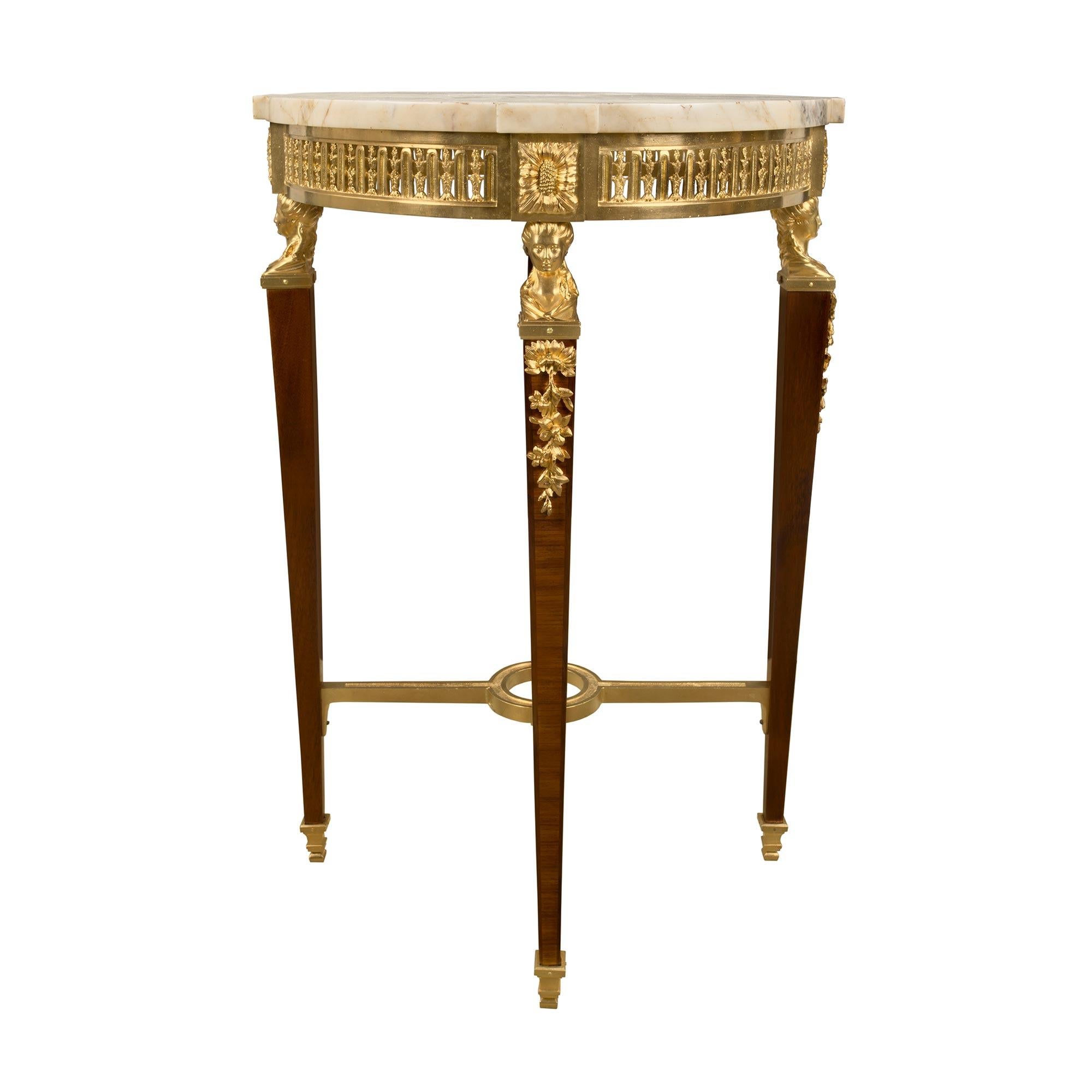 Ein sehr eleganter und einzigartiger französischer Beistelltisch im Stil Louis XVI des 19. Jahrhunderts aus Ormolu und Tulpenholz. Der Tisch wird von quadratischen, konisch zulaufenden Ormolu-Sabots unter den konisch zulaufenden Beinen mit