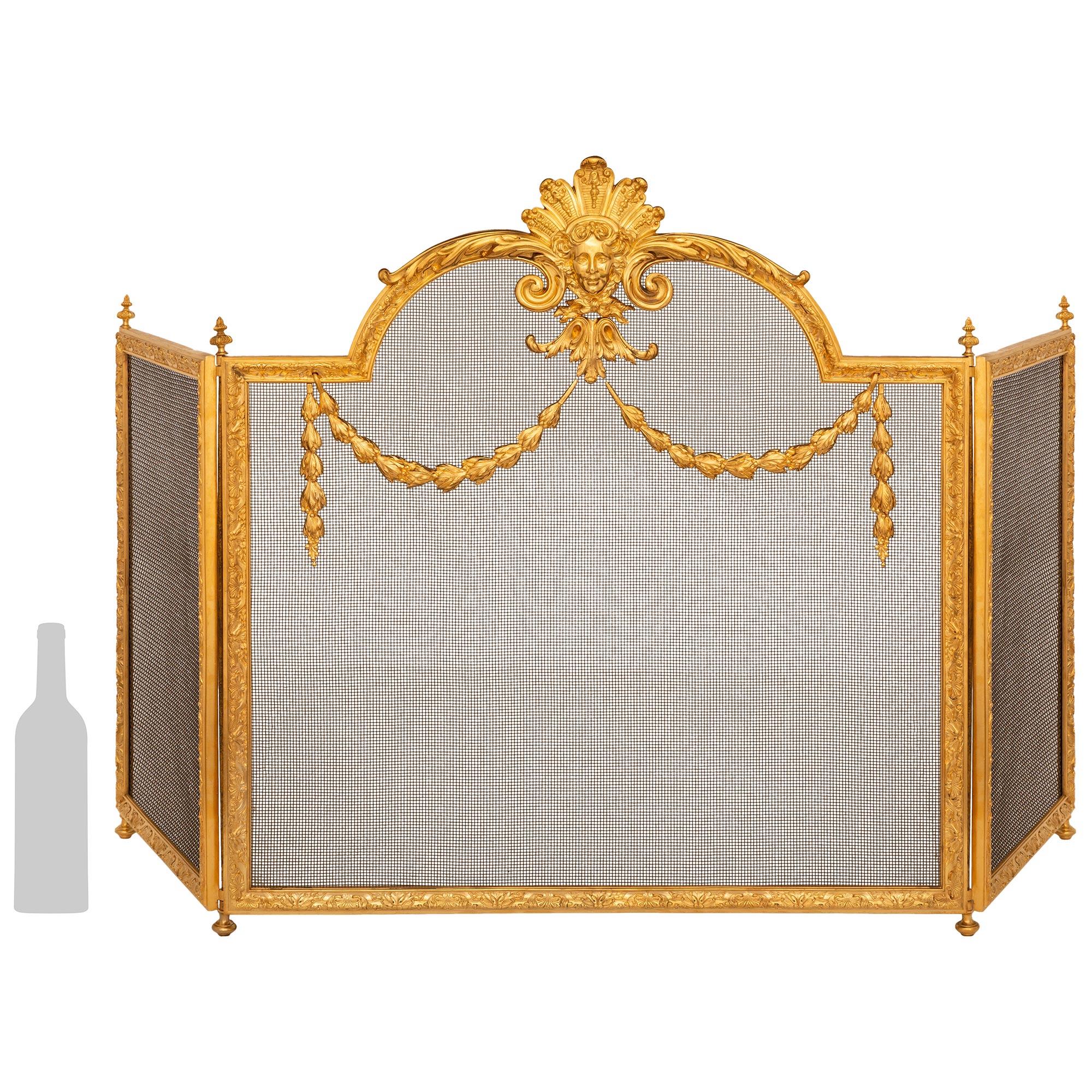 An extremely elegant French 19th century Louis XVI st. Ormolu fire screen. This attractive three panel fire screen is supported on four Ormolu topie shaped feet. Each panel is edged with wonderful scrolling foliate designs and topped with finely
