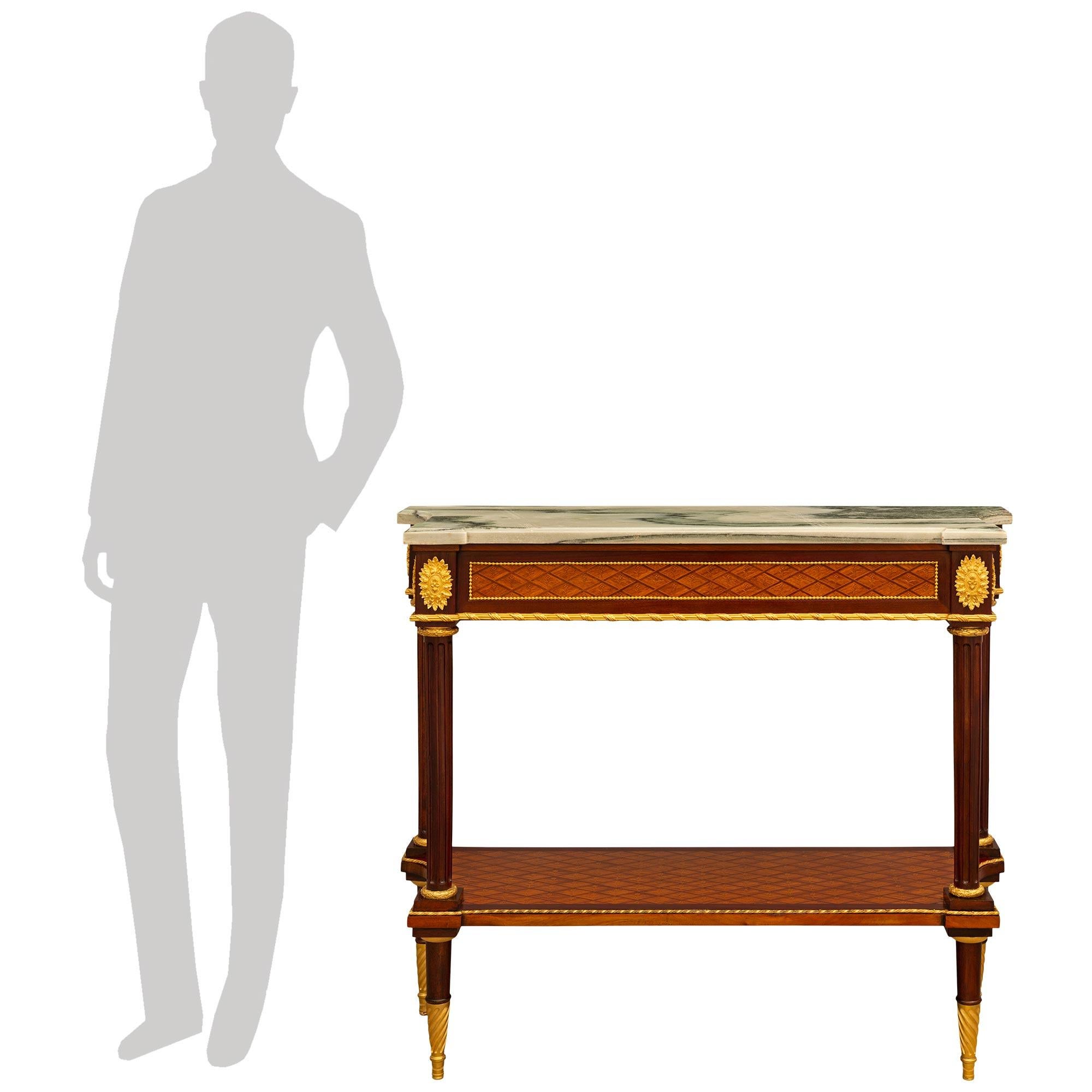 Impresionante y elegantísima consola francesa del siglo XIX, de estilo Luis XVI, de ormolu, caoba, madera de tulipán y mármol cipollino verde. Esta consola independiente realmente impresionante se eleva sobre cuatro patas redondas cónicas de caoba