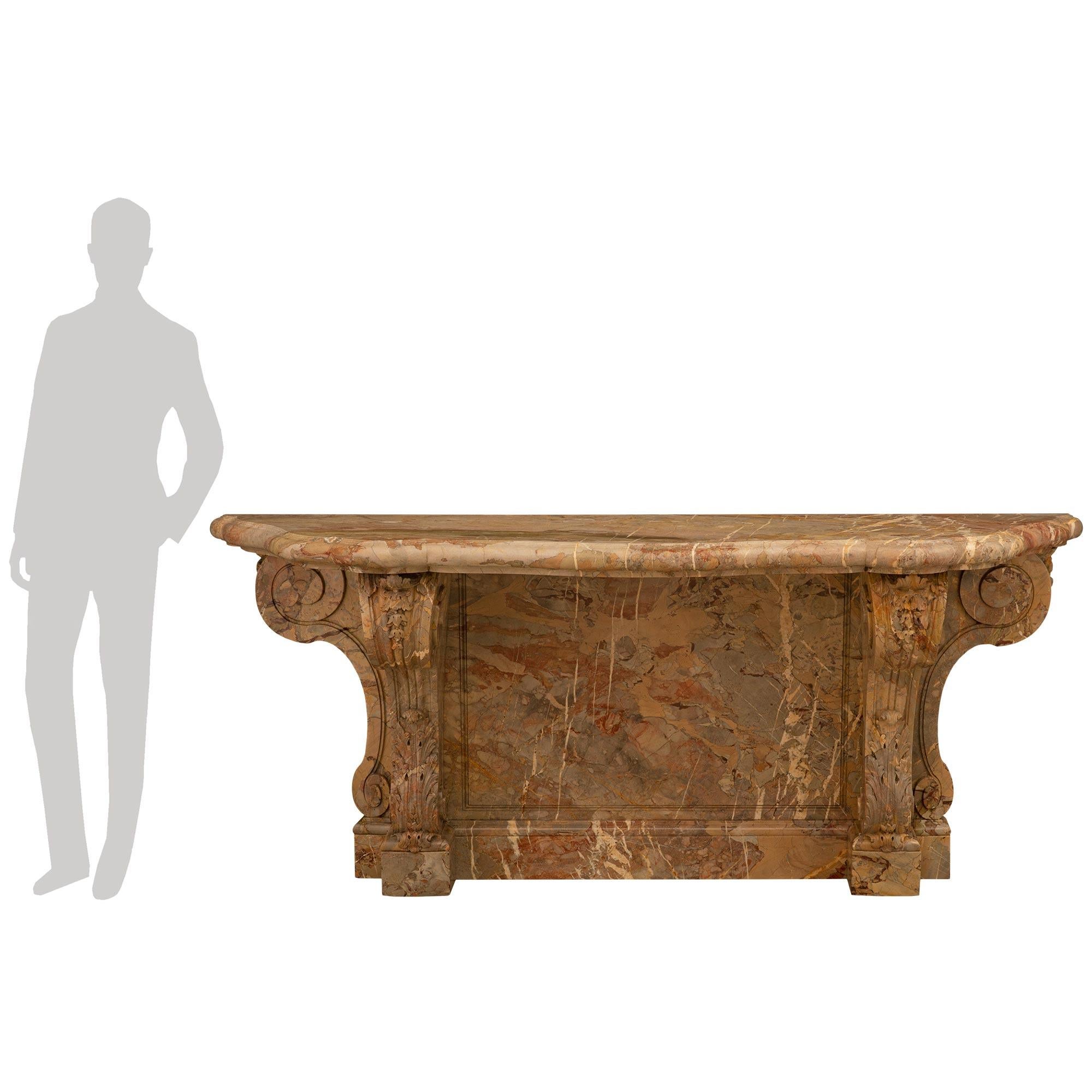 





A most impressive and large scaled French 19th century Louis XVI st. Sarrancolin marble console. The console is raised by two 'S' scrolled legs with richly carved bottom acanthus leaves and top carved foliage. The two supporting legs flank a
