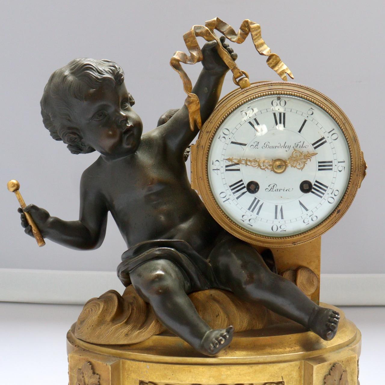 Chased Ormolu and Patinated Mantelpiece designed as a Cupid with a Drum
The porcelain dial enamelled with Arabic and Roman numerals
Bevelled Glass
Signed A.Beurdeley Fils Paris
The pendulum by Japy Frères 
Louis XVI style
Circa 1875

In