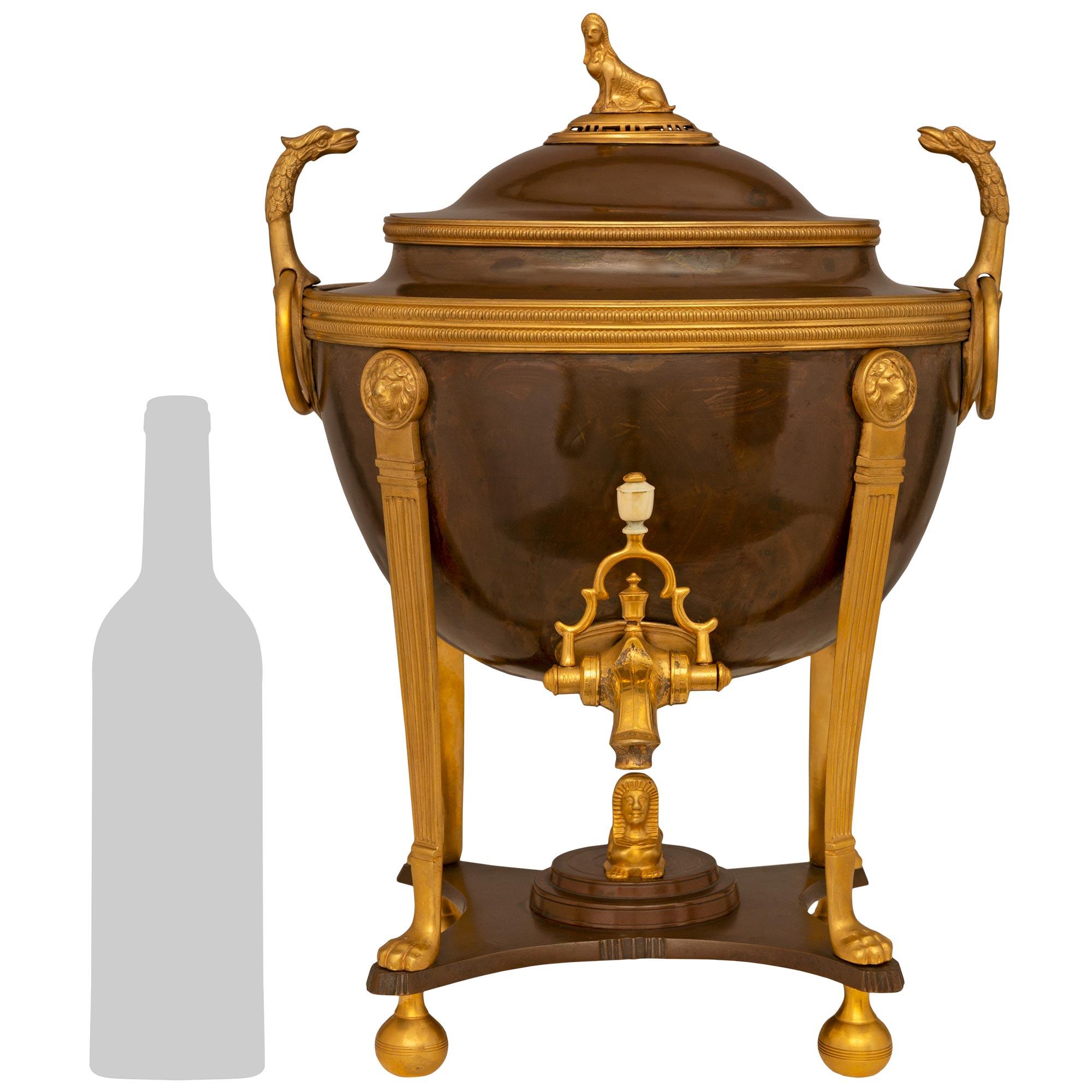 An exquisite French 19th century Neo-Classical st. Patinated Bronze and Ormolu Samovar. The most decorative hot water server is raised on Ormolu ball feet below a Patinated Bronze tier with concave sides. The tier has a central stepped platform
