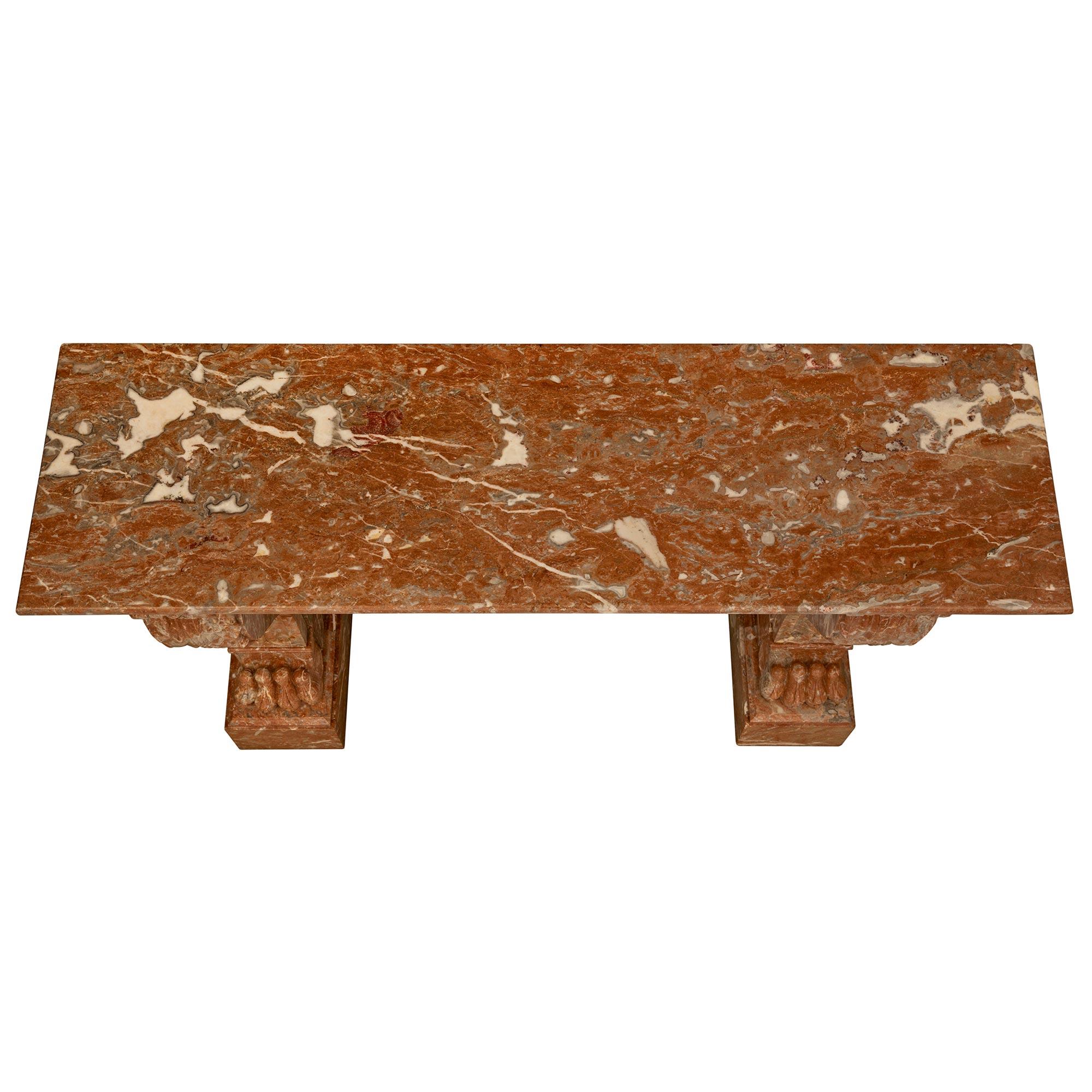 An impressive French 19th century Neo-Classical st. Rouge Royale marble console. The freestanding console is raised by striking block reserves with handsome paw feet below the beautiful scrolled fluted supports with richly sculpted palmettes at the