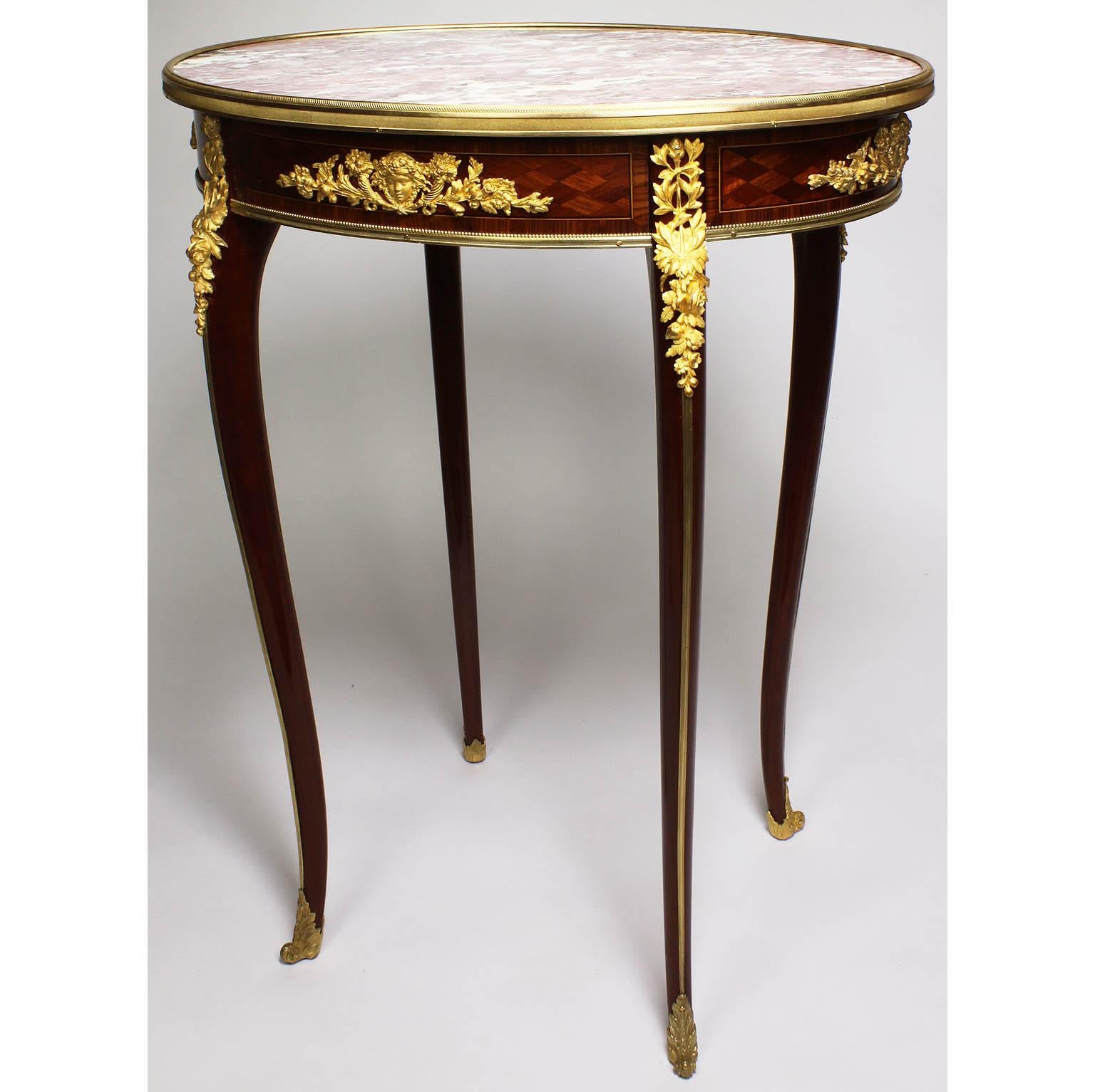 A fine French 19th century gilt-bronze (Ormolu) mounted, mahogany and tulipwood marquetry oval Gueridon (side) table with marble top, attributed to François Linke (1855-1946). The inset ovoid brocatelle d'Espagne marble top above a lozenge parquetry