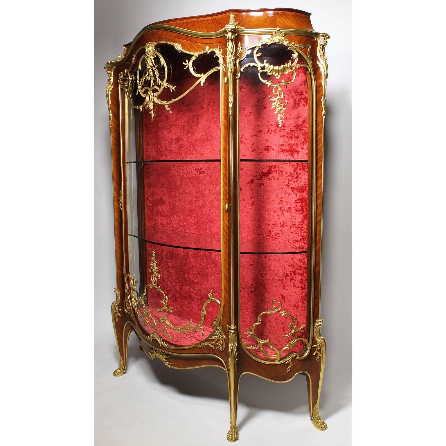 A fine French 19th-20th century Louis XV style Kingwood and ormolu-mounted single-door Vitrine, the demilune shaped cabinet with and arched bonnet, molded trim above a bombé glazed door framed with rocaille within a 