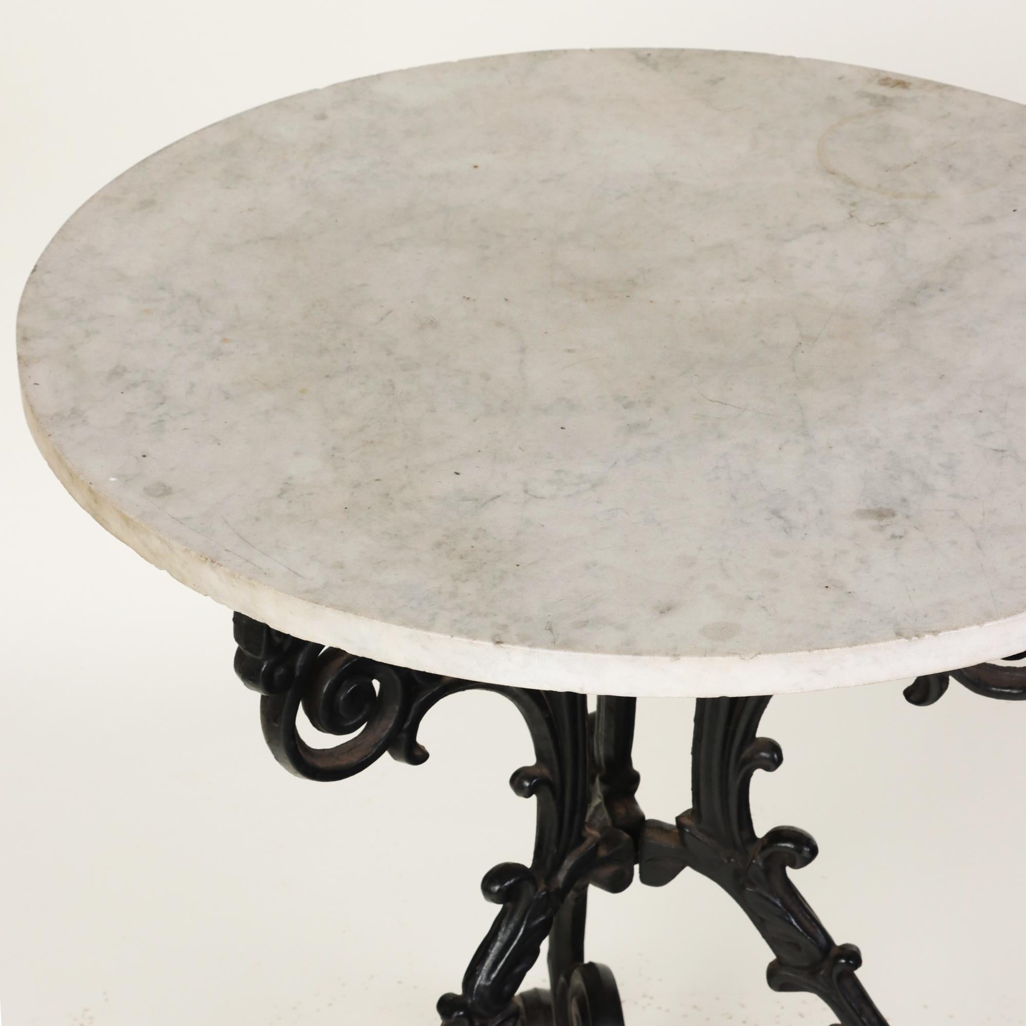 A French nineteenth century bistro table with white marble top resting on beautiful ornate cast iron tripodal pedestal base.