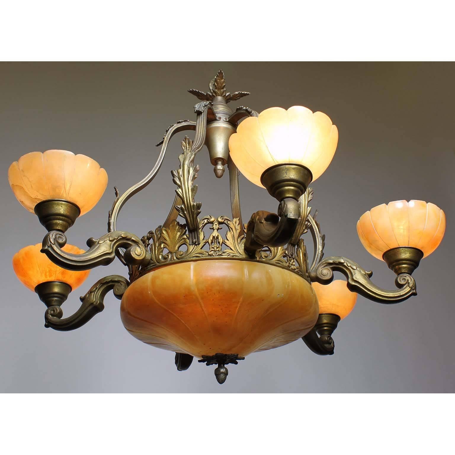 A French 20th century Art Deco bronze and carved veined caramel-colored alabaster six-light chandelier. The carved circular alabaster plafonnier, with an interior light, on a floral apron and banded bronze frame surmounted with six 