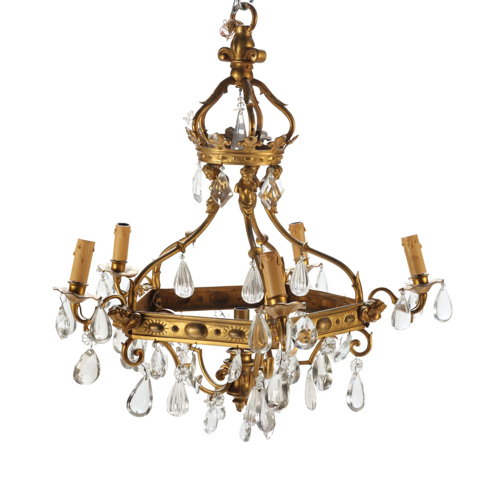 A French antique 5 light bronze and crystal chandelier decorated with cherubs faces.