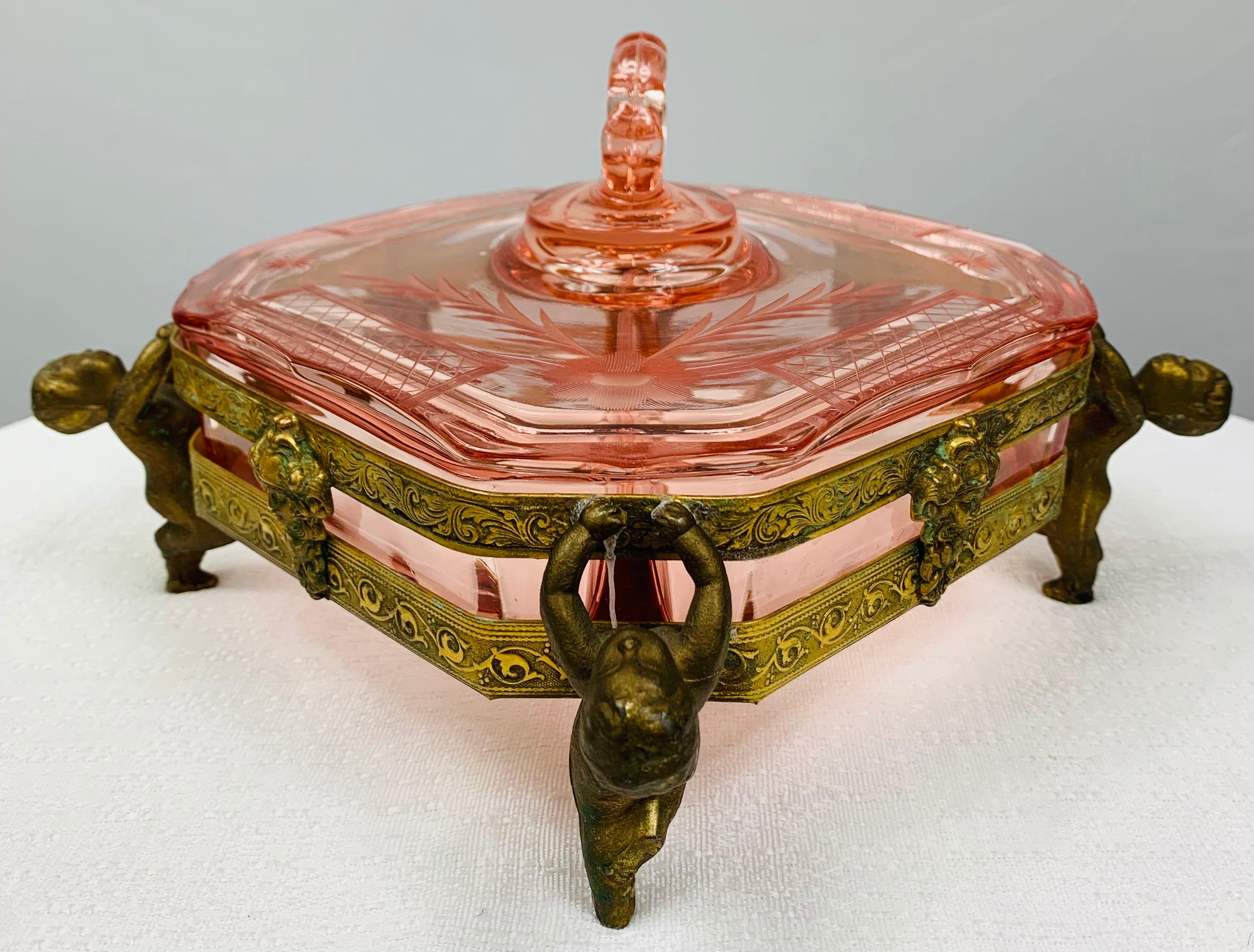 A beautiful antique 19th century French Louis XV bronze and cut glass jewelry box. The bronze inlay features four wingless putti in each corner and
a women (man) face sculpted in the middle of each side. The glass of square shaped box is nicely