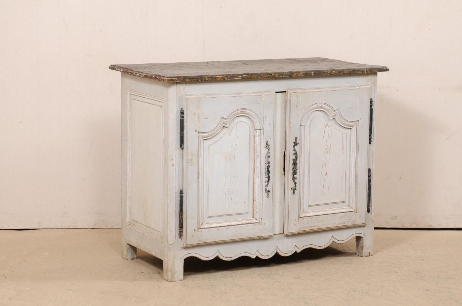 A French painted wood two-door buffet cabinet from the turn of the 18th and 19th century. This antique cabinet from France features a rectangular-shaped top with beveled edges, atop a case which houses a pair of nicely carved panel doors, flanked