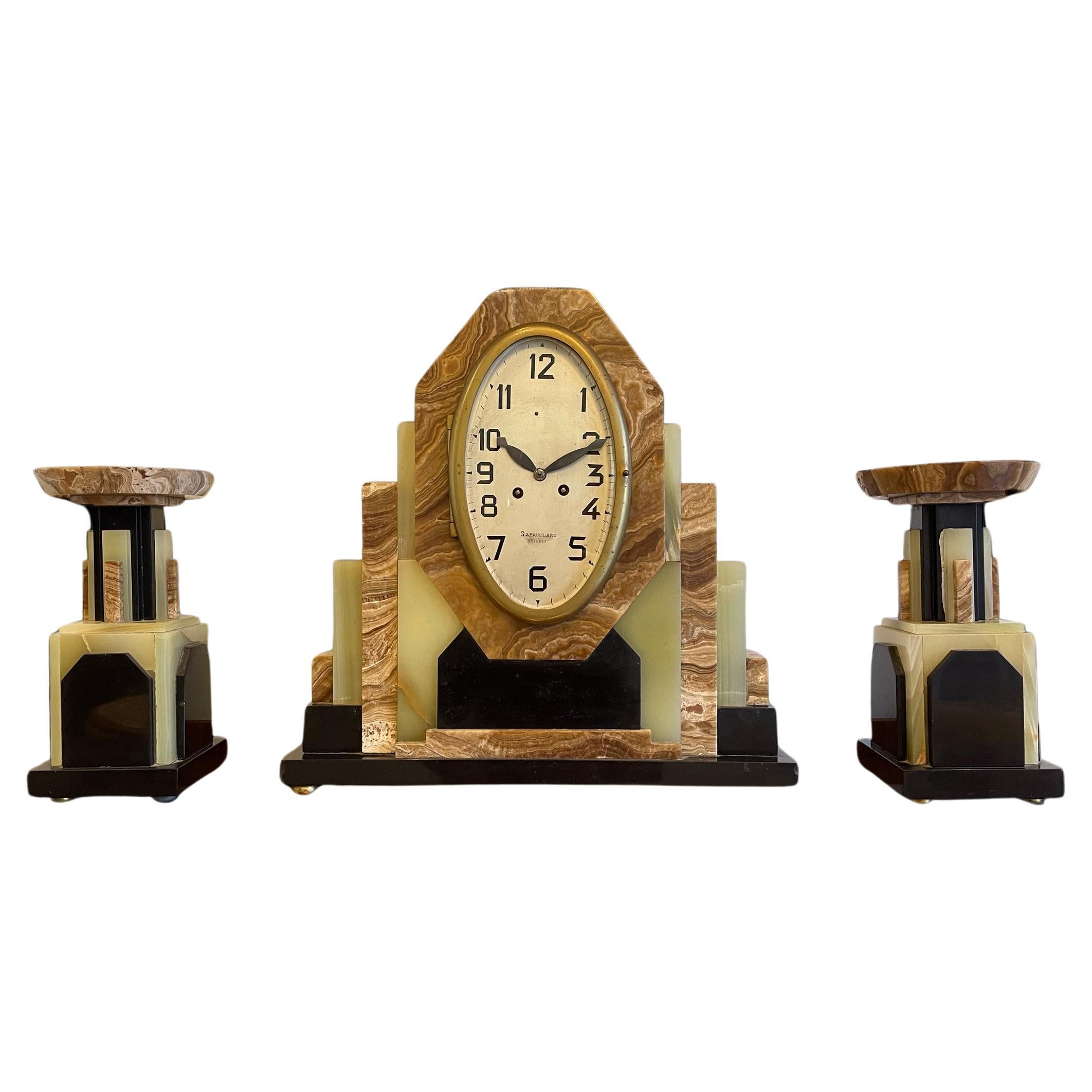 A French Art Deco Clock with its matching pair of Garnitures For Sale