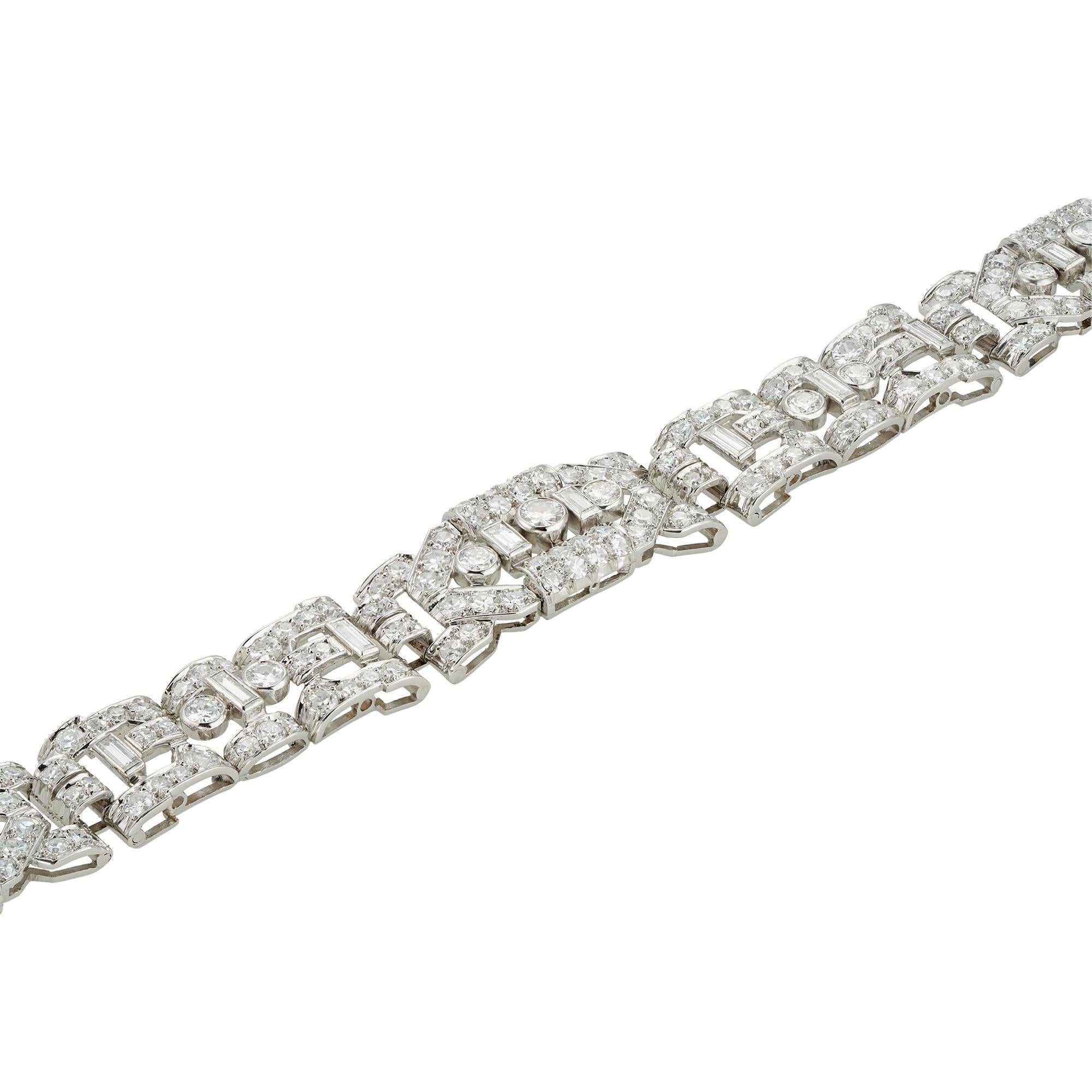 Bracciale Art Deco francese in platino con diamanti, composto da cinque pannelli flessibili e una chiusura dal design geometrico traforato e collegati da sei maglie di forma cilindrica, tutti incastonati con diamanti baguette, svizzeri e taglio