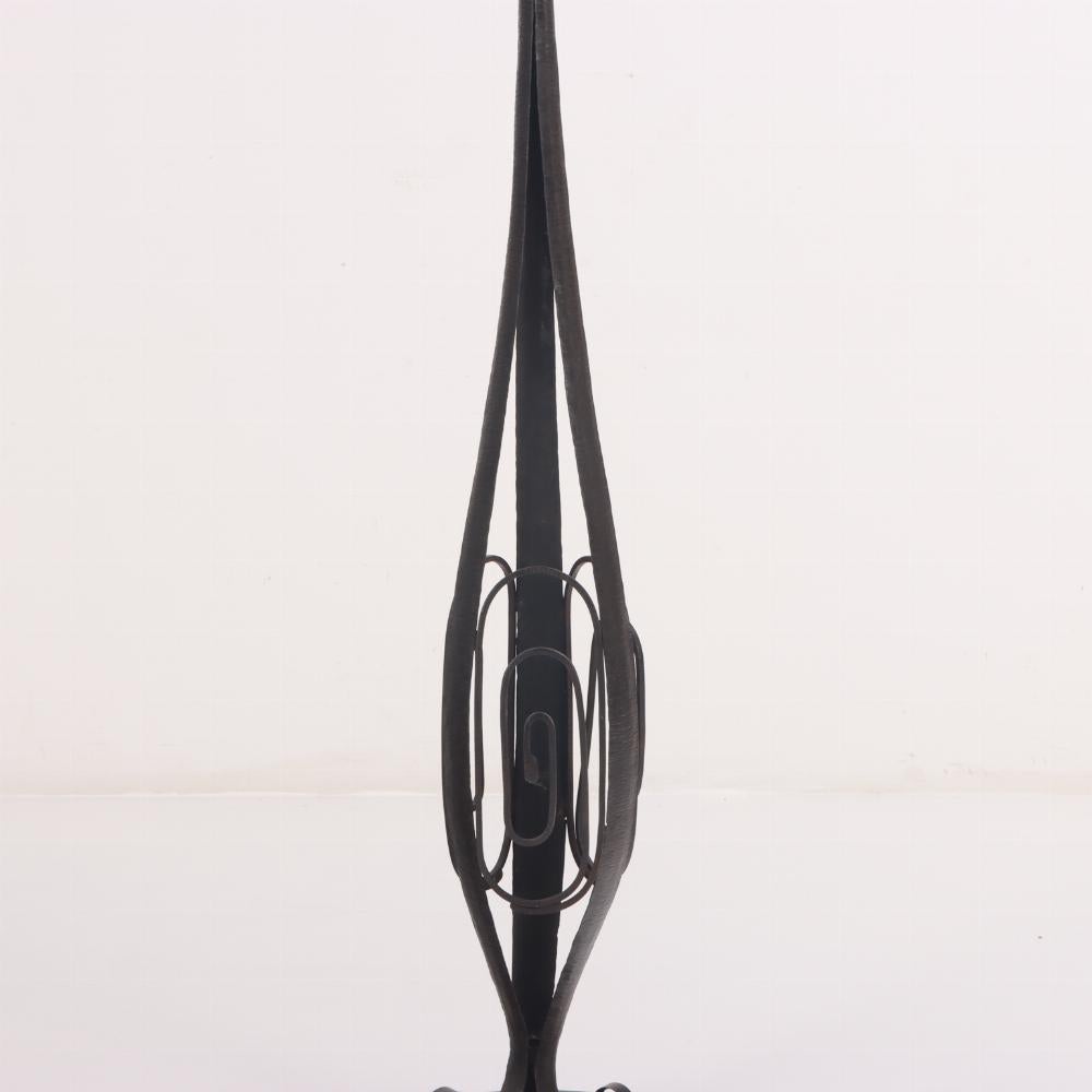 Un lampadaire en fer martelé à la main de l'Art déco français, C.C.C. 1930, avec des supports d'abat-jour à volutes au-dessus d'un standard bulbeux et d'une base ronde. L'abat-jour n'est pas inclus.