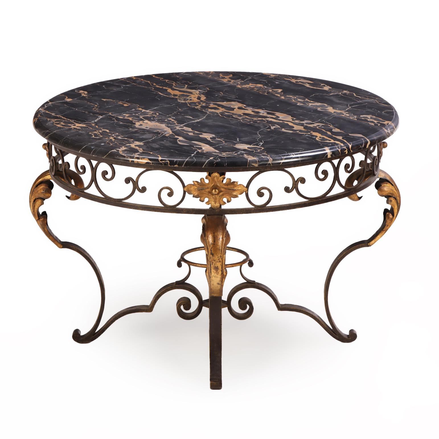 Une table d'appoint ou de salon en fer français, richement décorée de motifs feuillagés dorés, est surmontée d'une remarquable surface en marbre Nero. La base présente des volutes ouvertes, conférant une présence aérienne qui équilibre le poids du