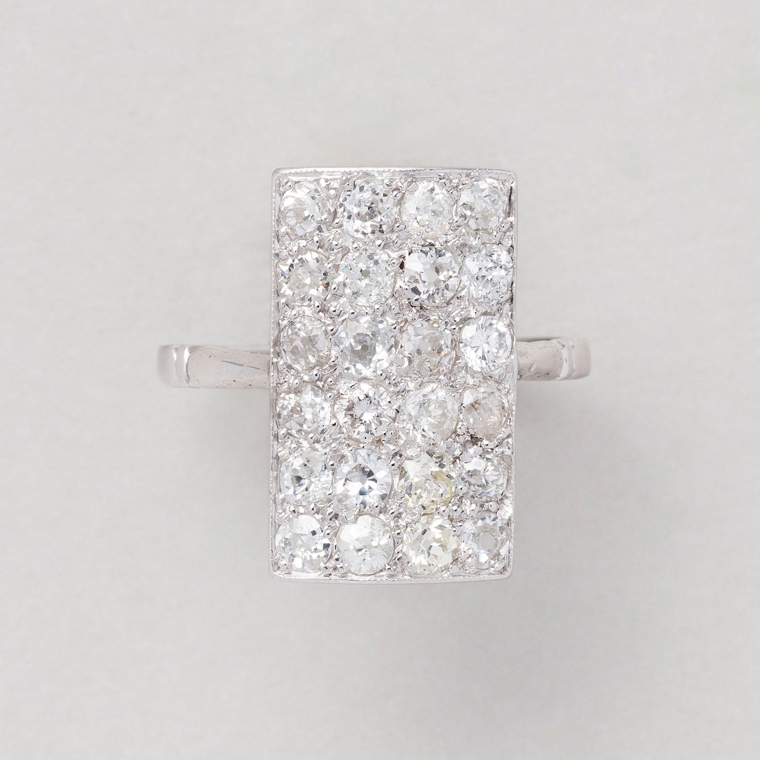 A delicate platinum Art Deco ring with a rectangular concave panel set with 23 old European cut diamonds and one (replaced) modern brilliant cut diamond (app. 1.68 ct., H-I / VS) with open worked sides, France, circa 1925 marked with French assay