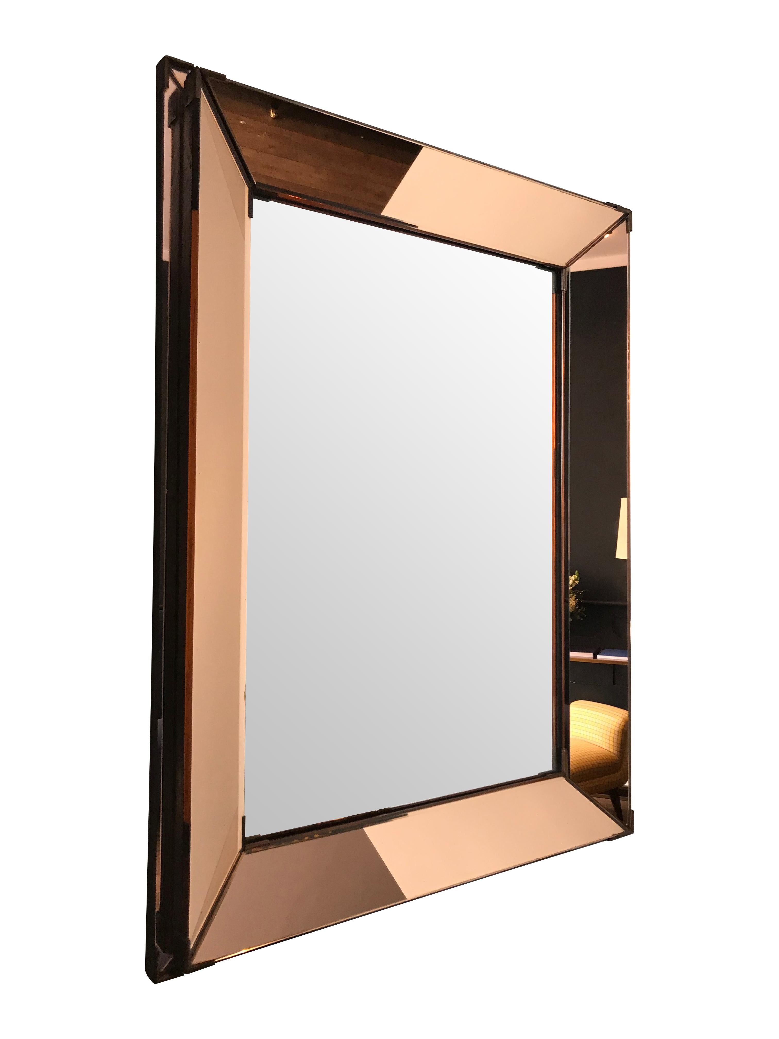 A French Art Deco Mirror with faceted and angled rose colored mirror frame with brass corner detail. The brass corners have not been polished but could be if required.