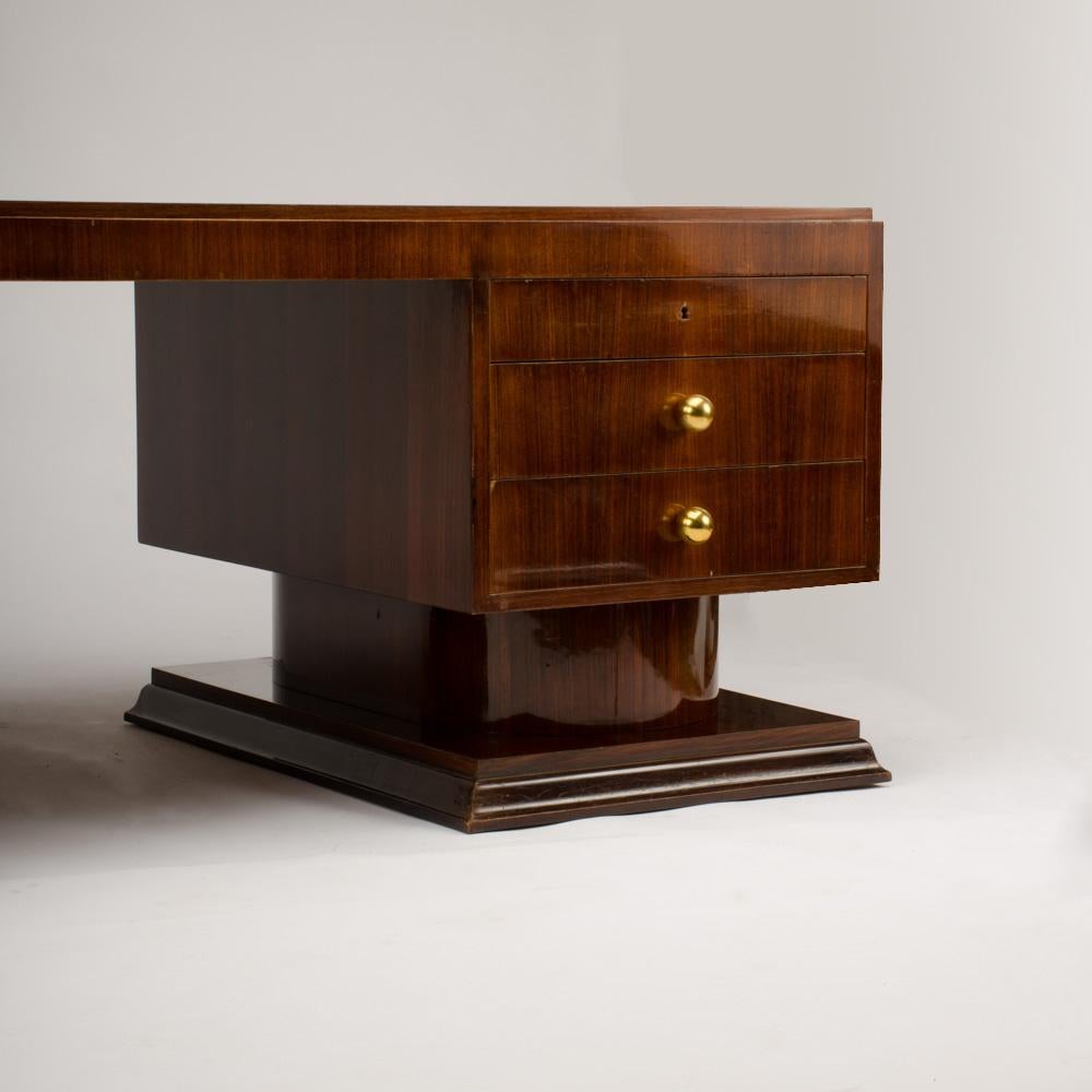 An imposing French rosewood Art Deco executive desk by Maurice Lafaille, circa 1930, having dual pedestal bases floating on recessed bases.