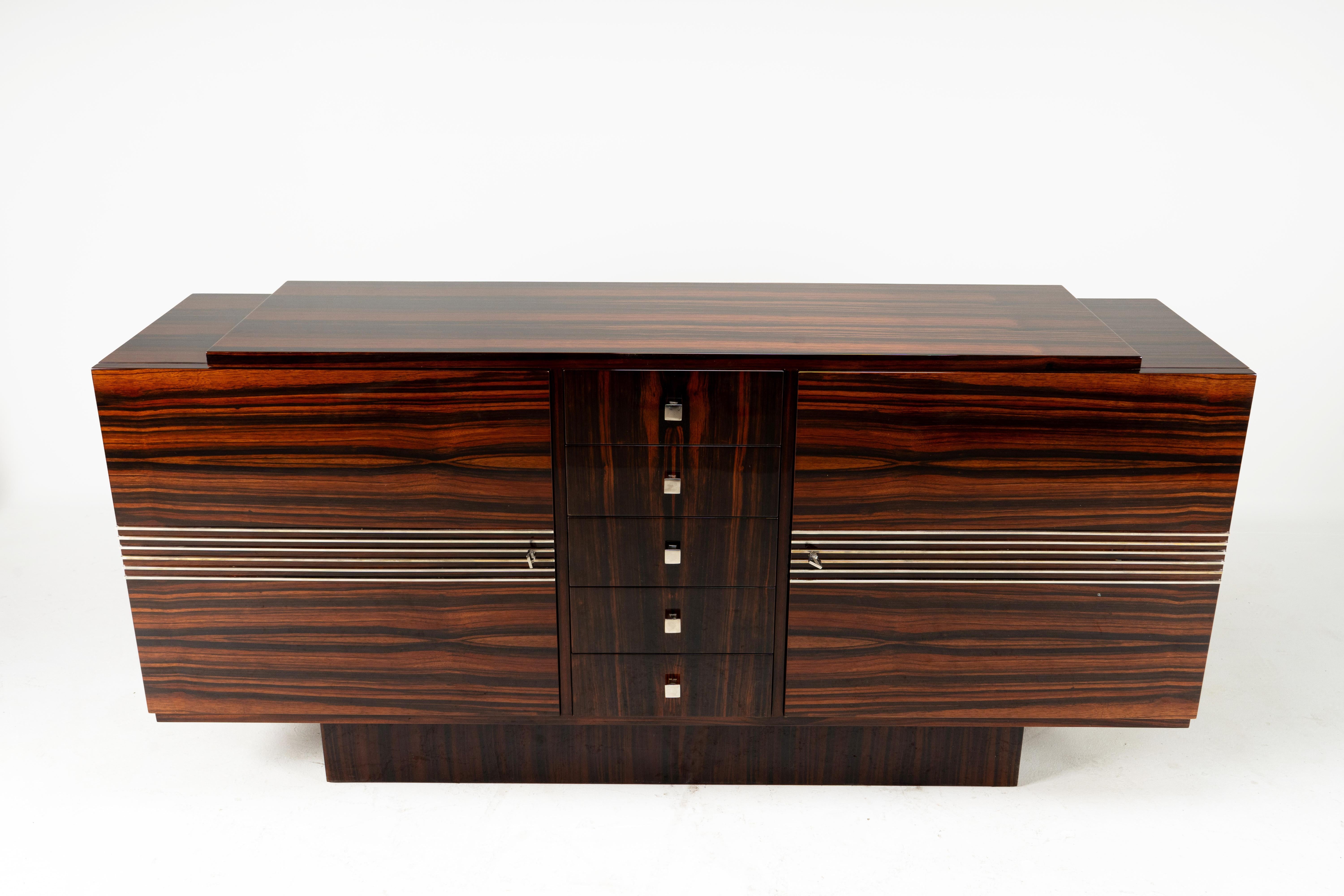 This exquisite French Art Deco sideboard, dating to the 1930s, is a superb example of early 20th-century decorative arts. The straight-grained and highly striated macassar veneer runs horizontally across the doors, accentuating the length and