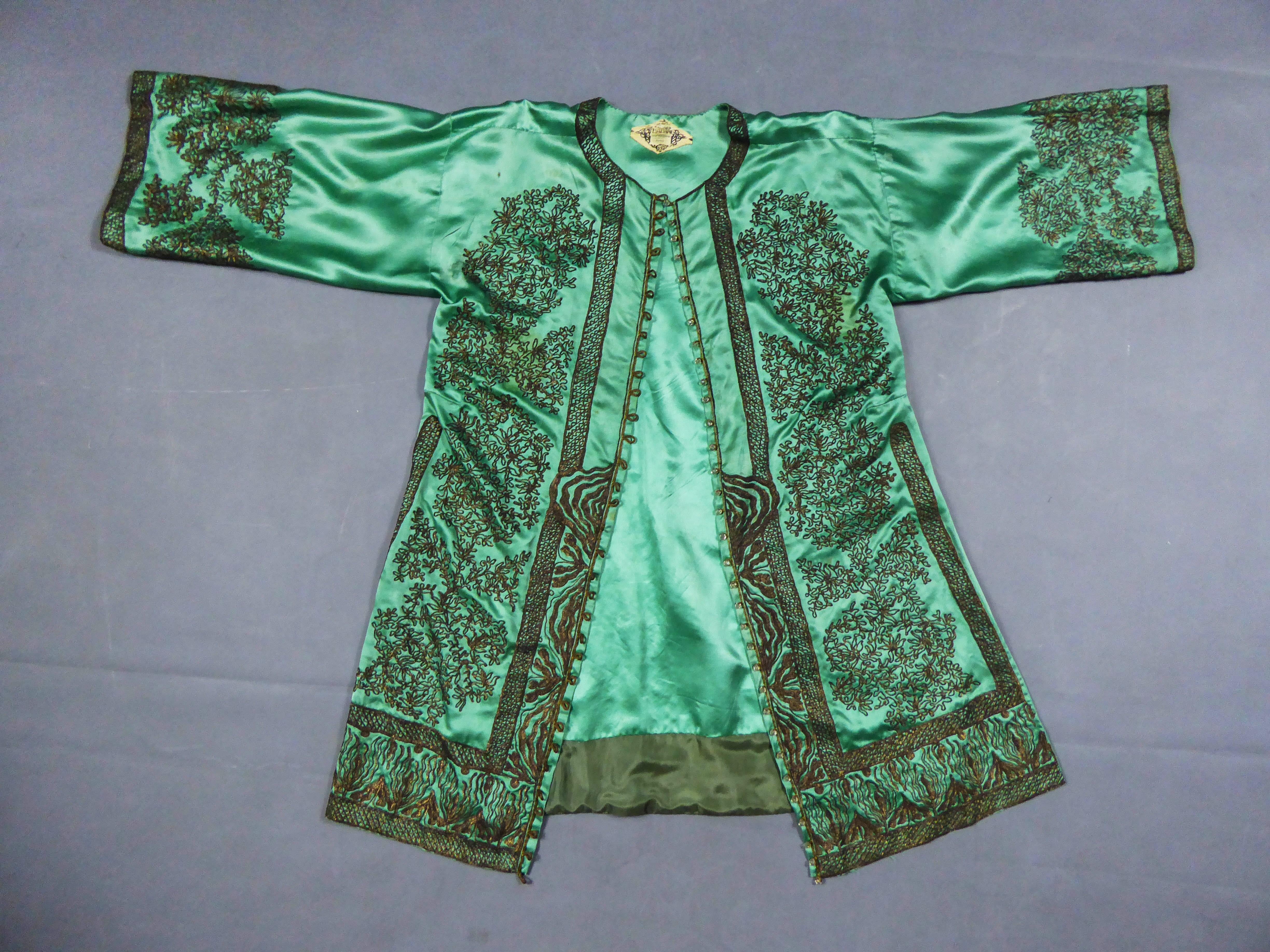 Um 1910/1920
Asiatische Produktion für Mode in Frankreich

Ein seltener, sammelwürdiger Party- oder Abendkaftan-Kimono aus grünem Seidensatin des berühmten Pariser Hauses Babani aus den 1920er Jahren. Kimono-Schnitt mit seitlichen Schlitzen.