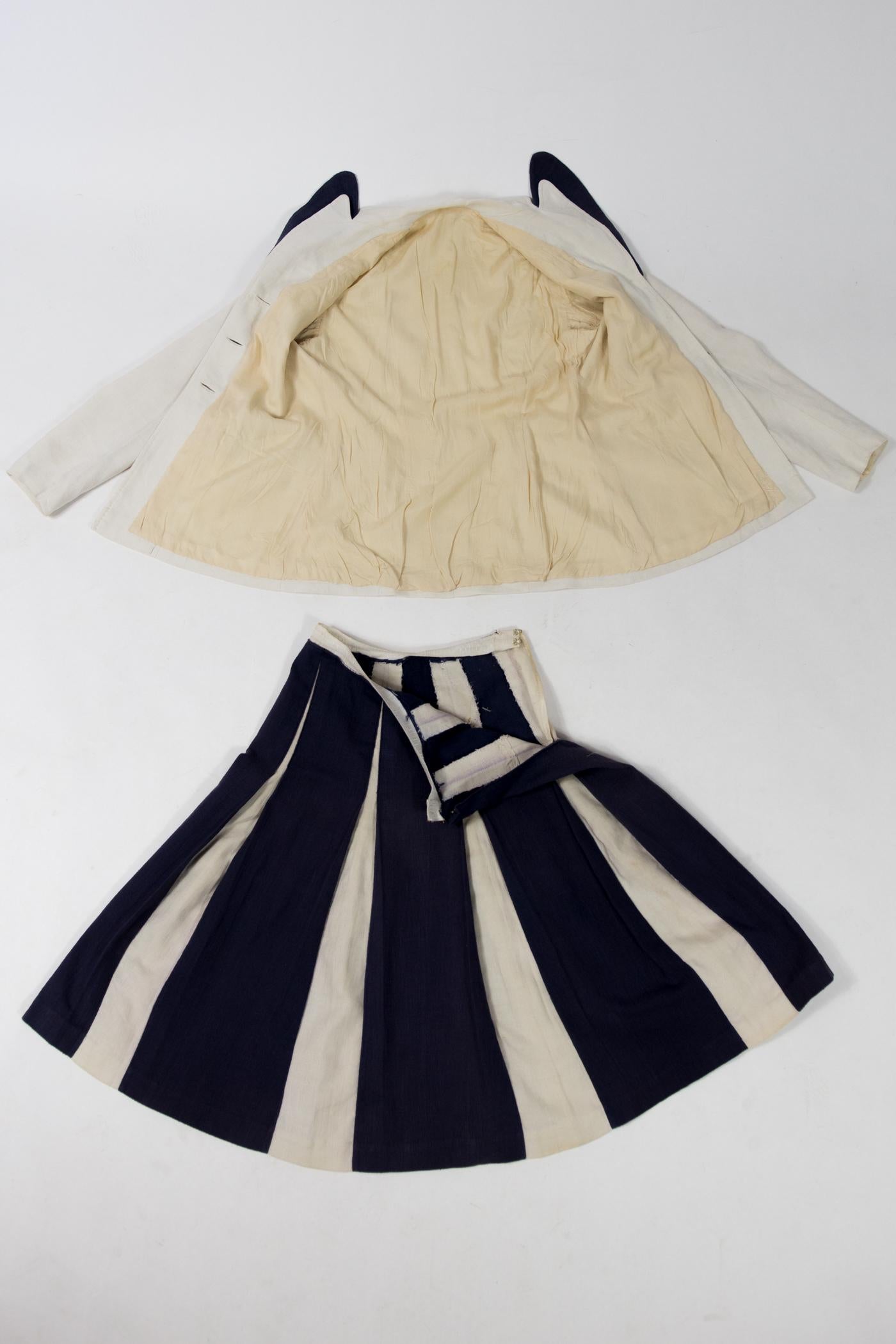Circa 1945/1950

France

Touching dressmaker's skirt suit in navy and cream canvas in line with the post-war Bar style. Fitted jacket in white linen / cotton canvas highlighted with navy canvas applied to the rounded collar and to the back of the