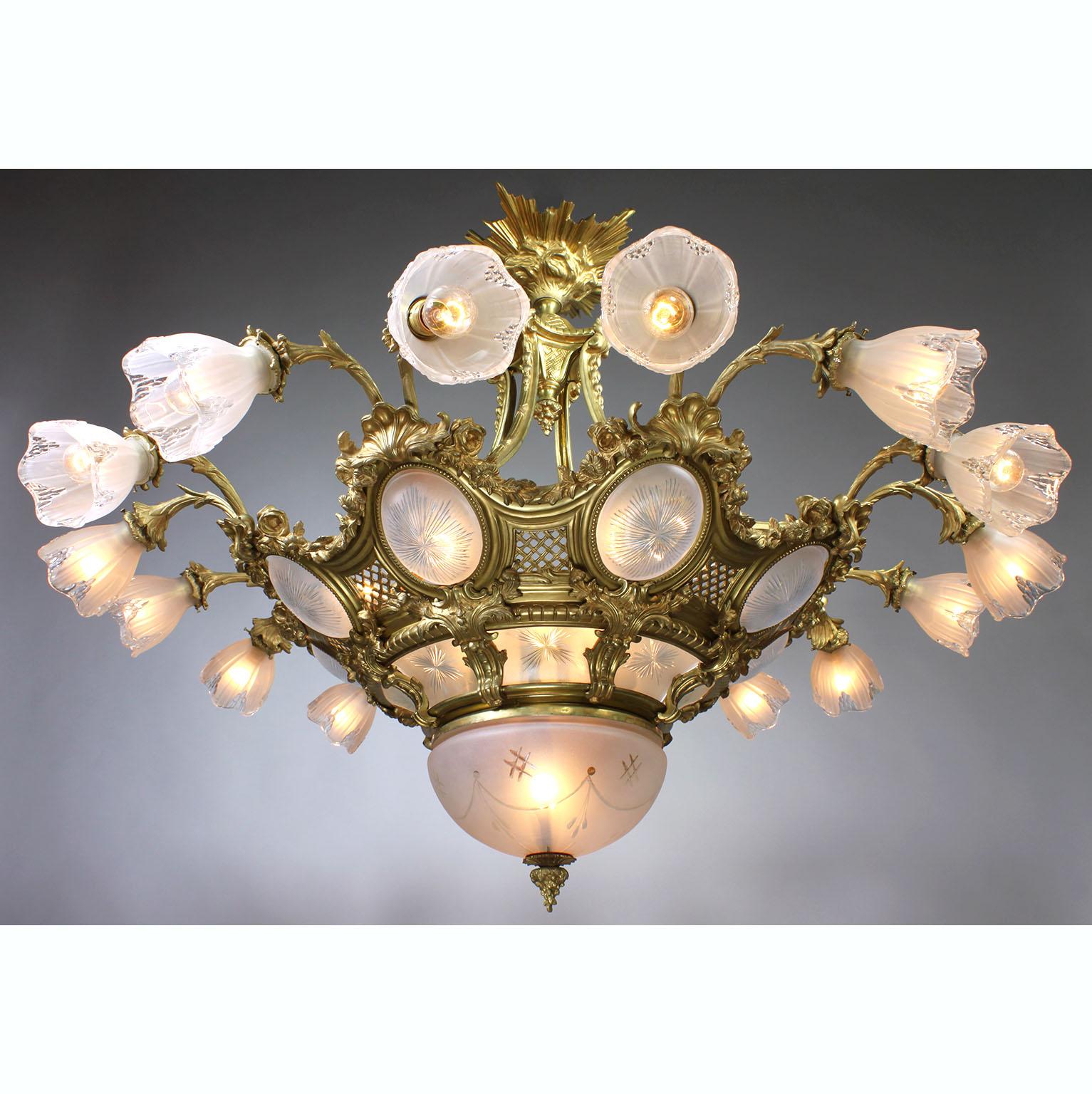 A large and impressive French Belle Époque gilt-bronze and molded glass sixteen-light plafonnier chandelier. The large ovoid pierced gilt-bronze frame surmounted with eight pairs of floral scrolled light-branches, each fitted with a frosted molded
