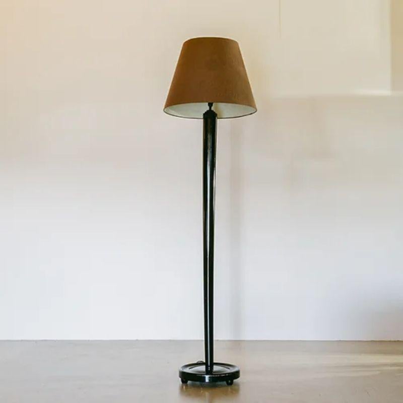 A simple black lacquered, French tapered columnar floor lamp on a cylinder base, 1950s.