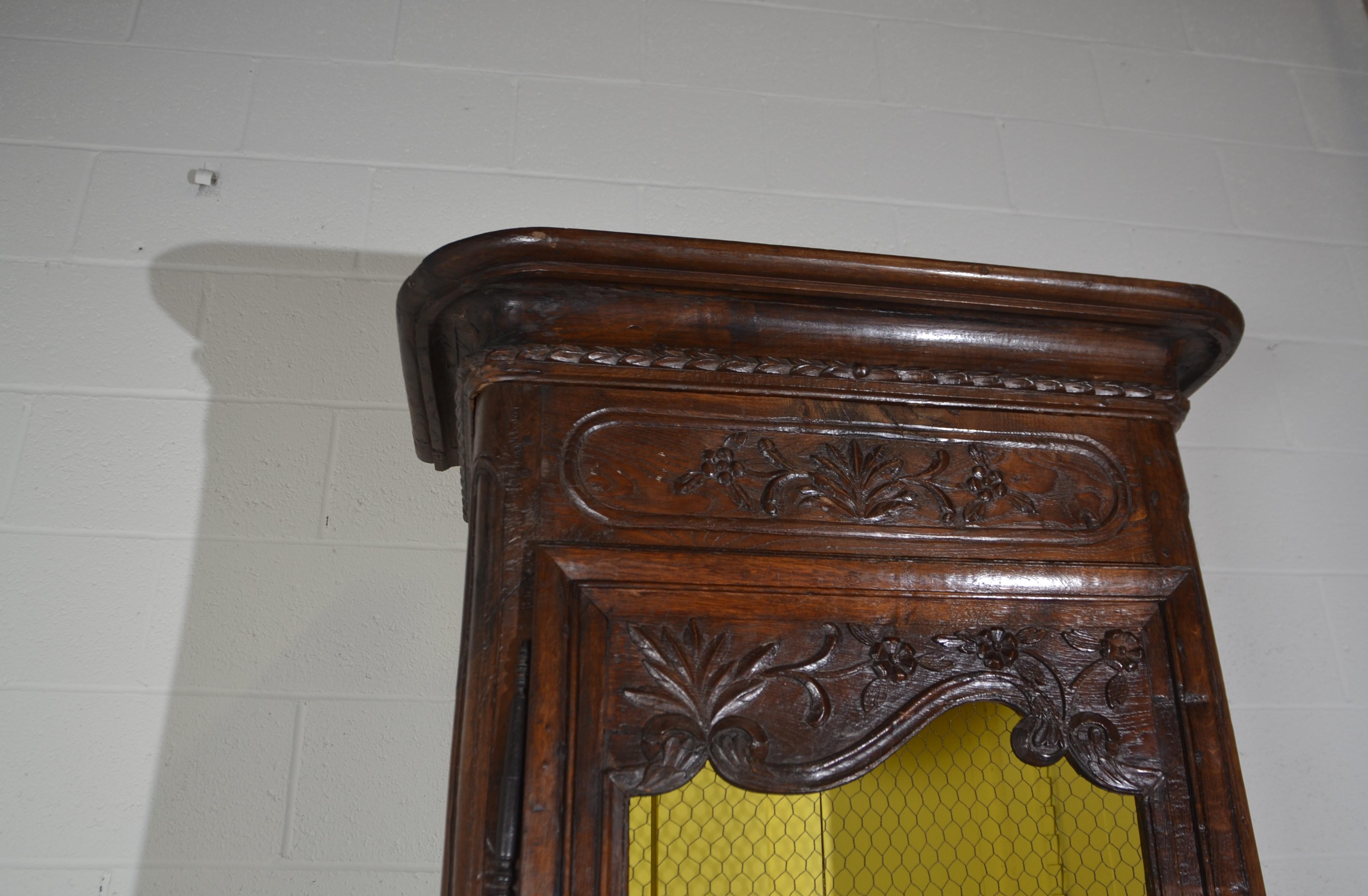 A French Bonnetiere with a Glazed door with chicken wire. Fine carvings to the top, center and base. Good size for a smaller room Nice condition. c.1780.