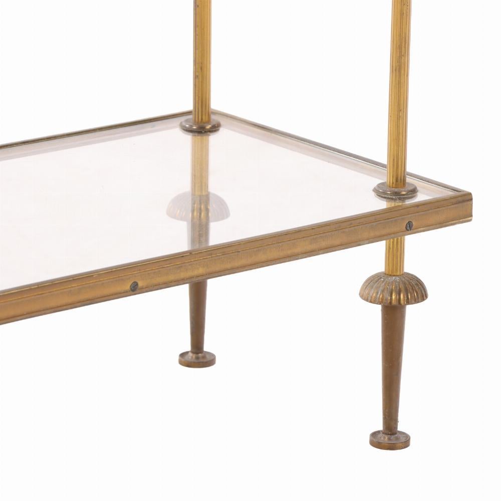 The table with nicely inset thick glass top over a conforming shelf, both suspended within straight reeded legs terminating in tapering circular feet. A wonderful table to use a dry bar or additional vanity space.