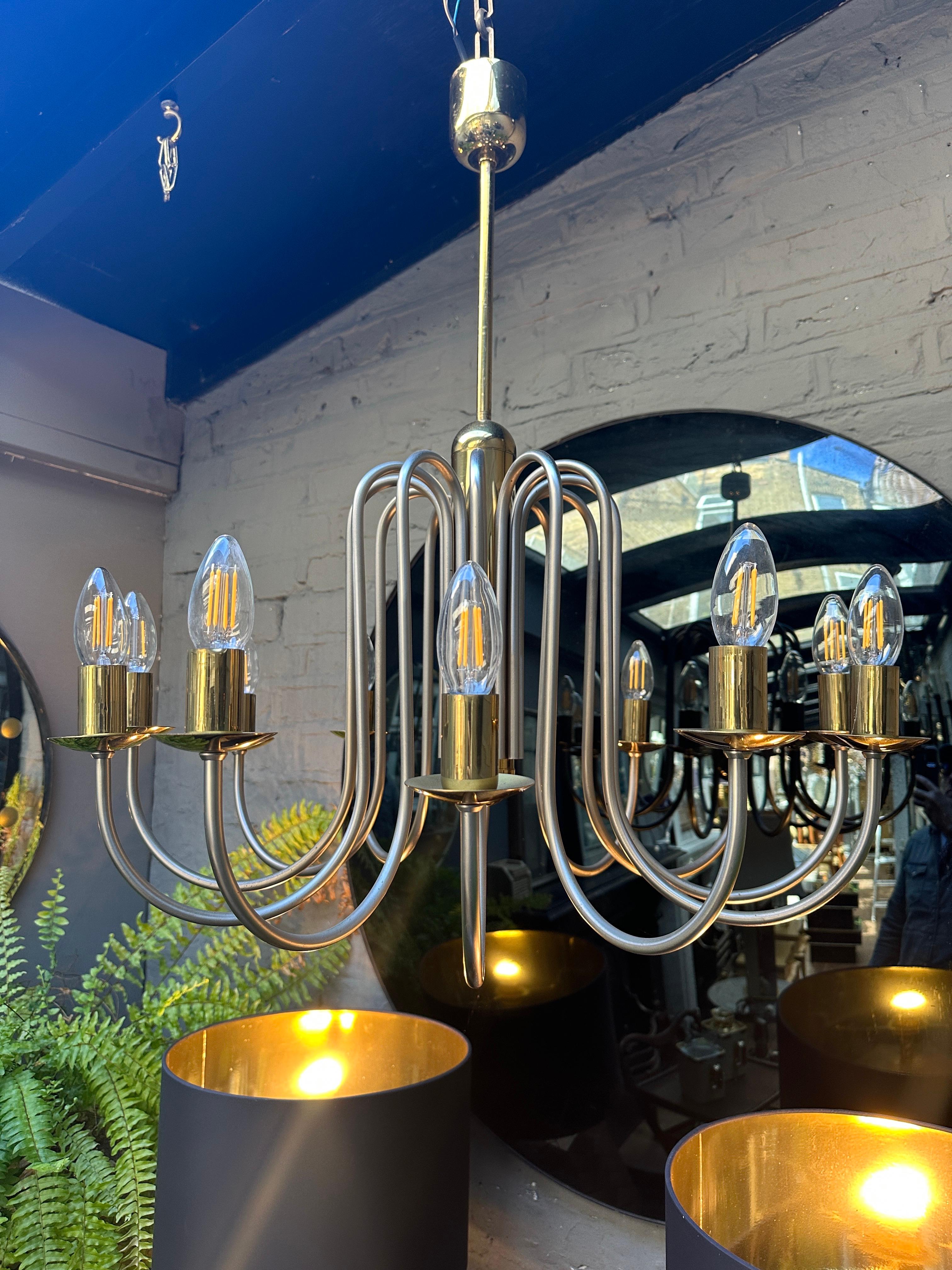 Un lampadario a 12 bracci in ottone laccato e nichel nel gusto della metà del secolo, con i bracci ampi e satinati e gli accenti in ottone laccato, luminosi anche se ora caldi. Elegante nella forma e di buone dimensioni. 

Francese, circa alla fine