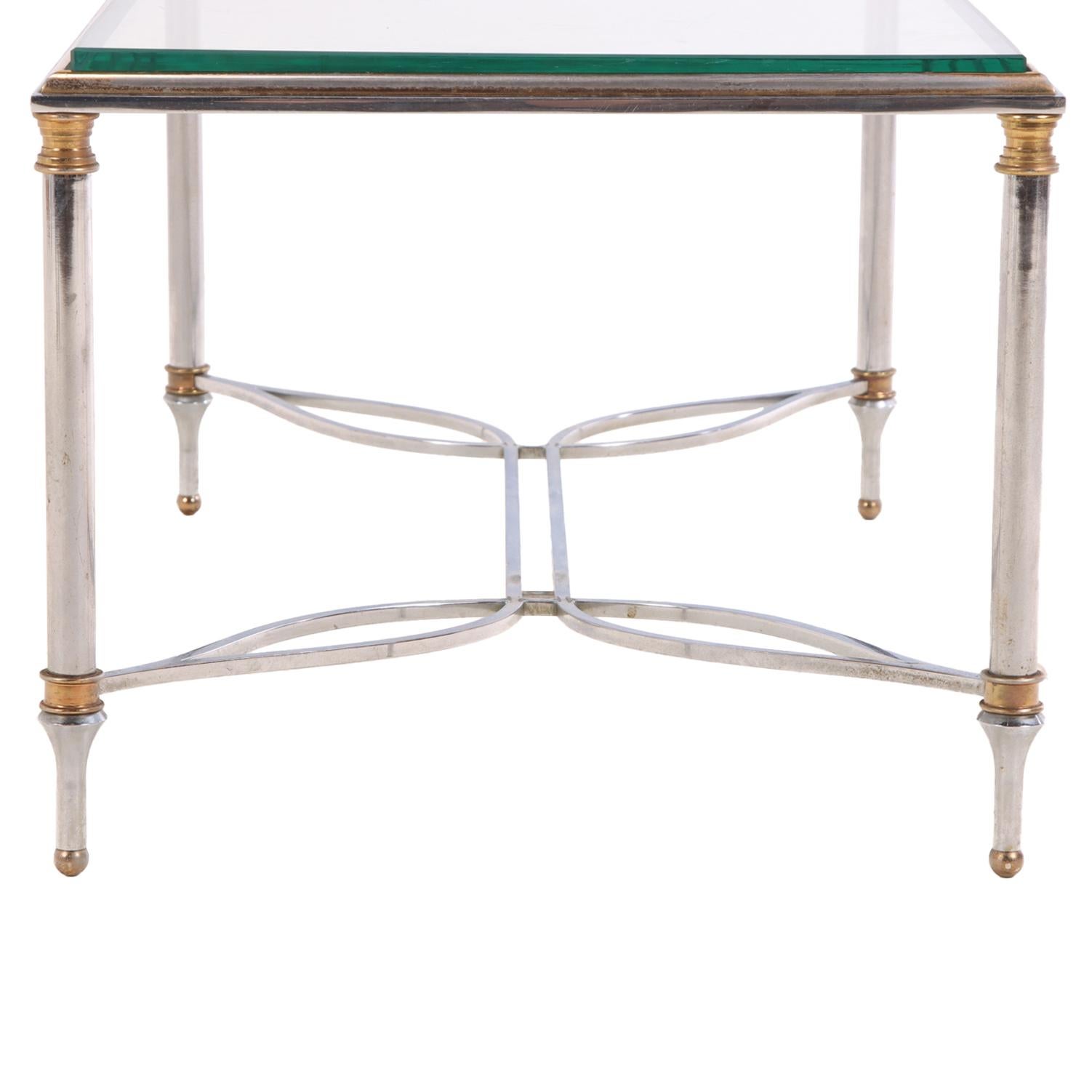 The rectangular glass top rests within a gilt-brass frame, supported by steel legs with brass accents and joined by a open work H - stretcher. The design reflects Jansen’s signature neoclassical aesthetic, combining clean modern lines with refined