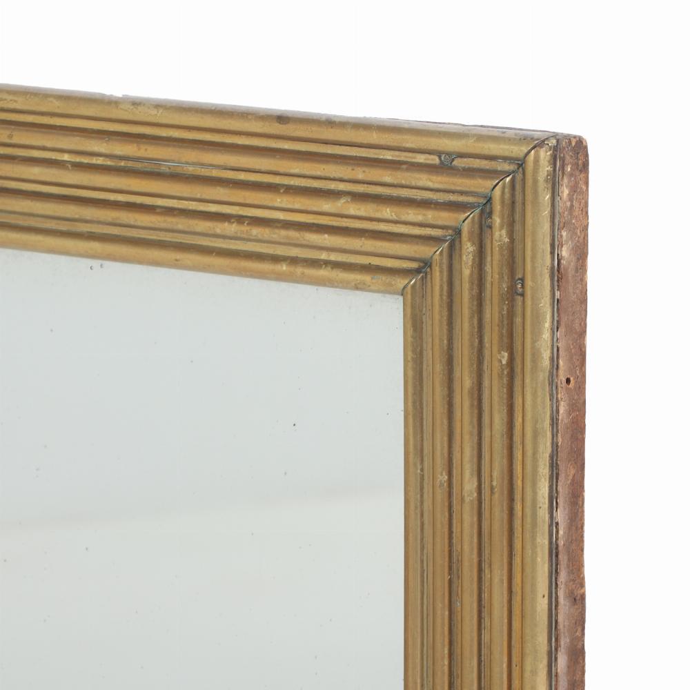 The rectangular mirror within a reeded brass frame with wonderful minimalist lines. An elegant and simple addition!