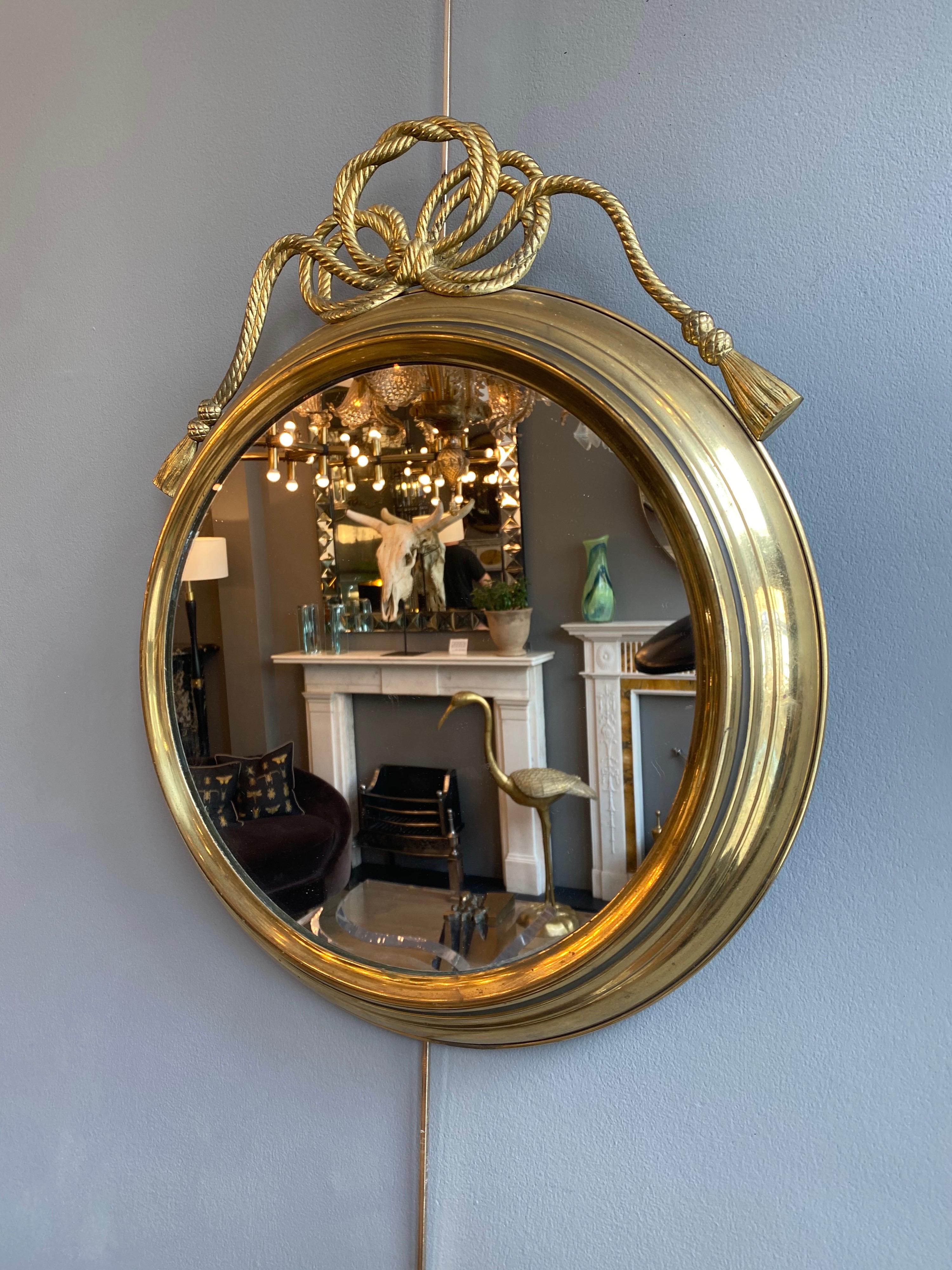 A midcentury brass circular mirror with rope tied pediment. Original glass and patina,

French, circa 1950s.