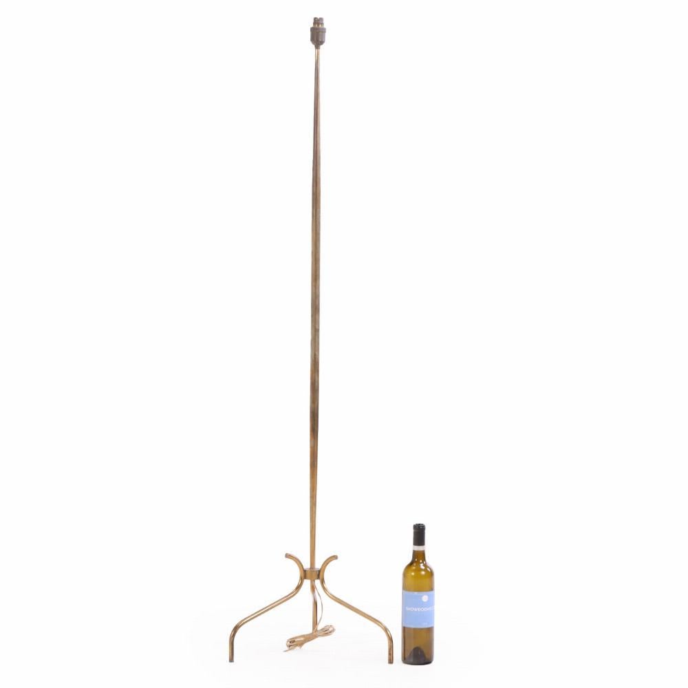 Una lampada da terra francese elegante e raffinata del 1945 circa, realizzata in ottone con una raffinata base a treppiede. Le tre gambe sottili convergono in un fusto centrale, creando una struttura leggera ma stabile per un'offerta a lampadina
