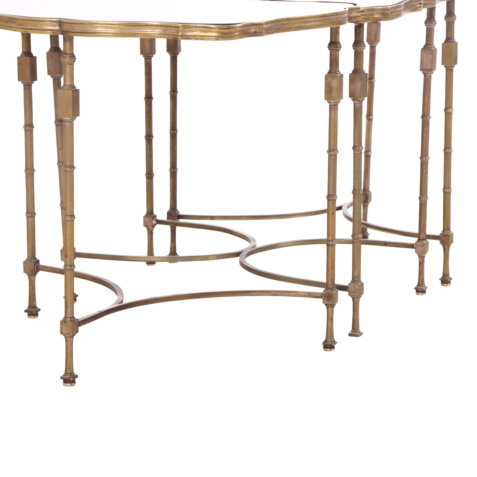 Une table basse française étonnante avec une base sculpturale en laiton composée de trois éléments avec un clin d'œil au style néoclassique. Chaque section supporte un plateau en verre miroir, créant un contraste luxueux entre la finition métallique