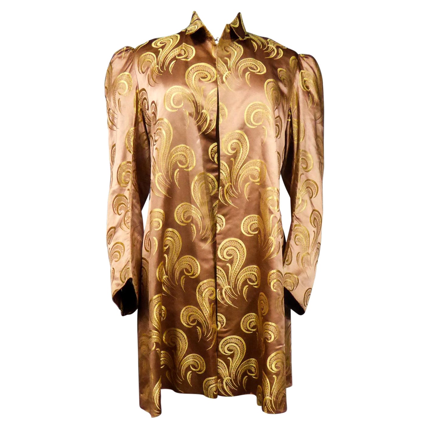 Circa 1930/1950
France
Evening or party jacket inspired by Amazone style, in brown silk satin with gold stylized patterns in volutes, feathers and panaches. This is a reuse of an older dress because the Brocaded satin silk is to date between 1890